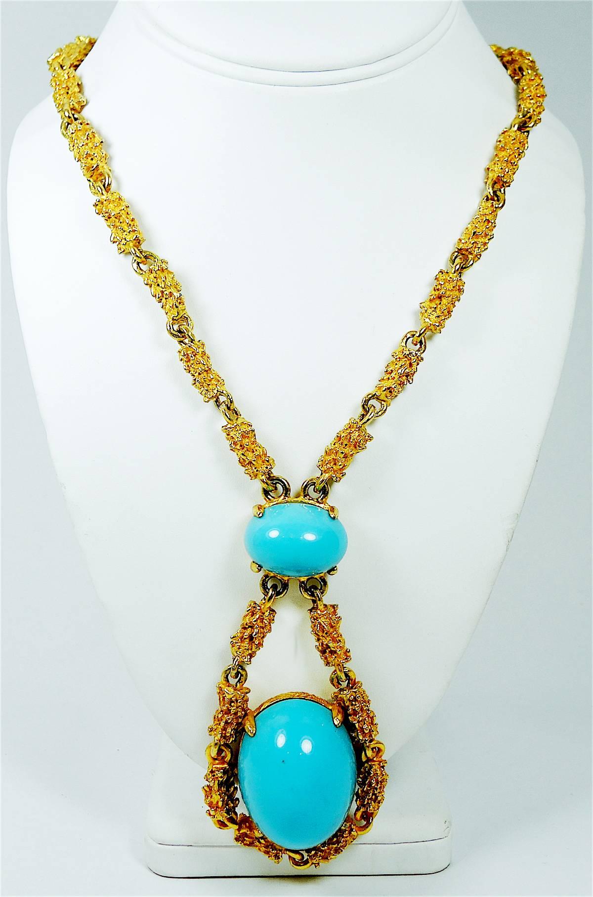 Alexis Kirk is known for bold designs like this beautiful faux turquoise cabochon drop that dangles from a heavily etched gold tone chain. The necklace measures, from top to bottom, 27” x 1/4” and the drop measures 4” x 2”. This necklace has a