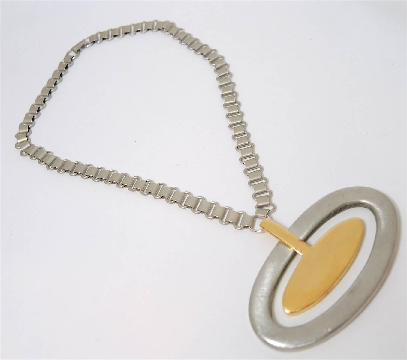 This necklace is just perfect. You can wear silver & gold together! It has a large pendant that is oval shaped with another pendant connected in the center. The necklace measures 16” x 1/4” and the pendant is 2” x 3”. This necklace has a fold over