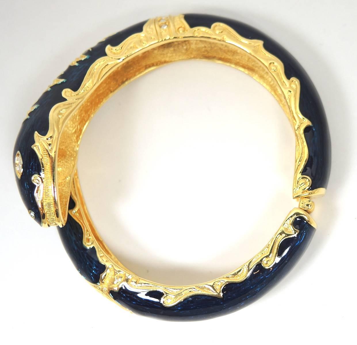 This Joan River’s bracelet features a serpent with rich midnight blue enameling and brilliant rhinestone accents in a gold tone setting. This clamper bracelet measures 2-1/8” x 1” and will fit a 7-1/2 to 8 wrist. It is signed “Joan Rivers” and is in