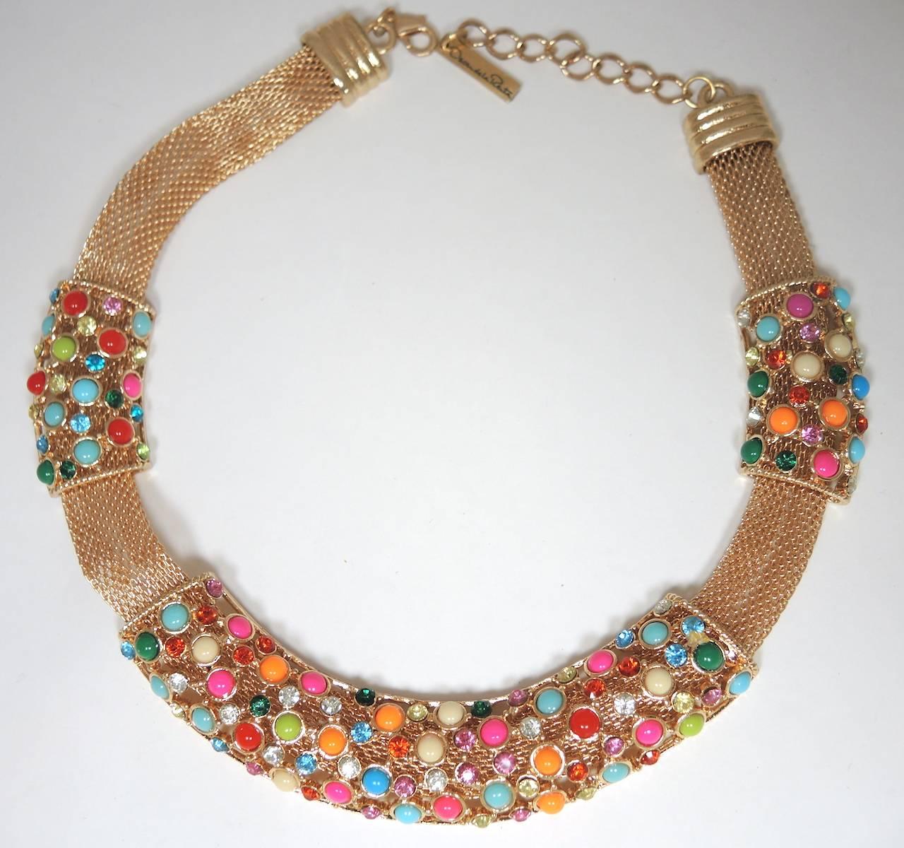 This stunning Oscar de la Renta necklace features a gold tone mesh chain with 3 movable sections of multi-color cabochon & rhinestones. The necklace measures 19” x 1-1/8” with a lobster clasp. It is signed “Oscar De La Renta” and is in excellent