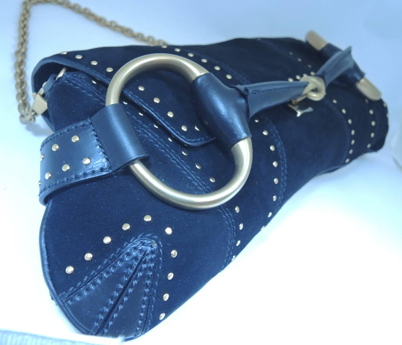 This is an authentic beautiful couture designer Gucci handbag that is made of black leather suede. The entire outside lining of the bag has small round gold-tone decor and the inside has a soft leather lining. The strap has a golden link chain that