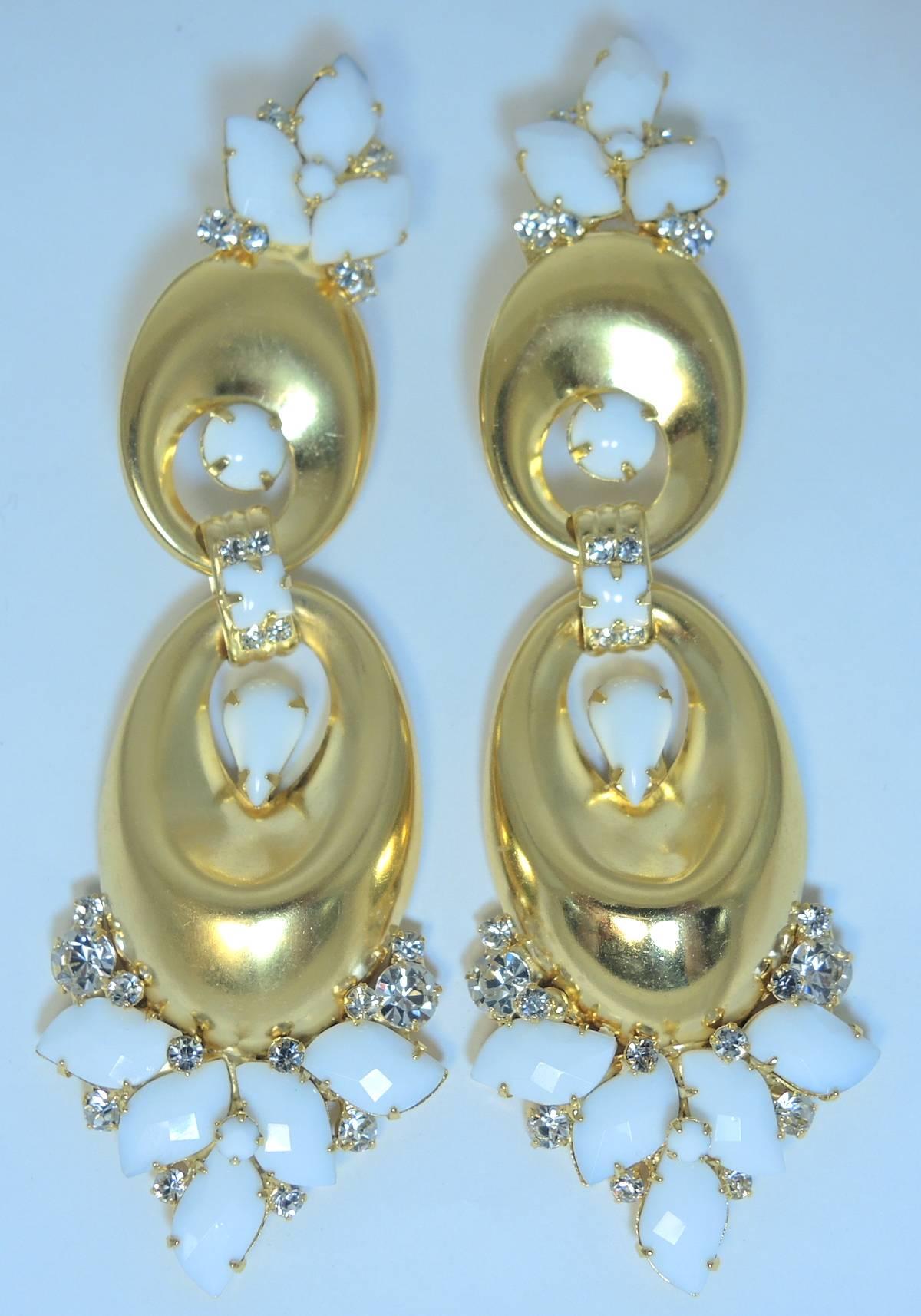 These are one-of-kind- long earrings by Robert Sorrell.  They feature two golden discs adorned with white faux pearl leaves and crystal accents. They measure a whopping 5” x 1-1/4” and are signed “Sorrell Originals”. They are in excellent condition.