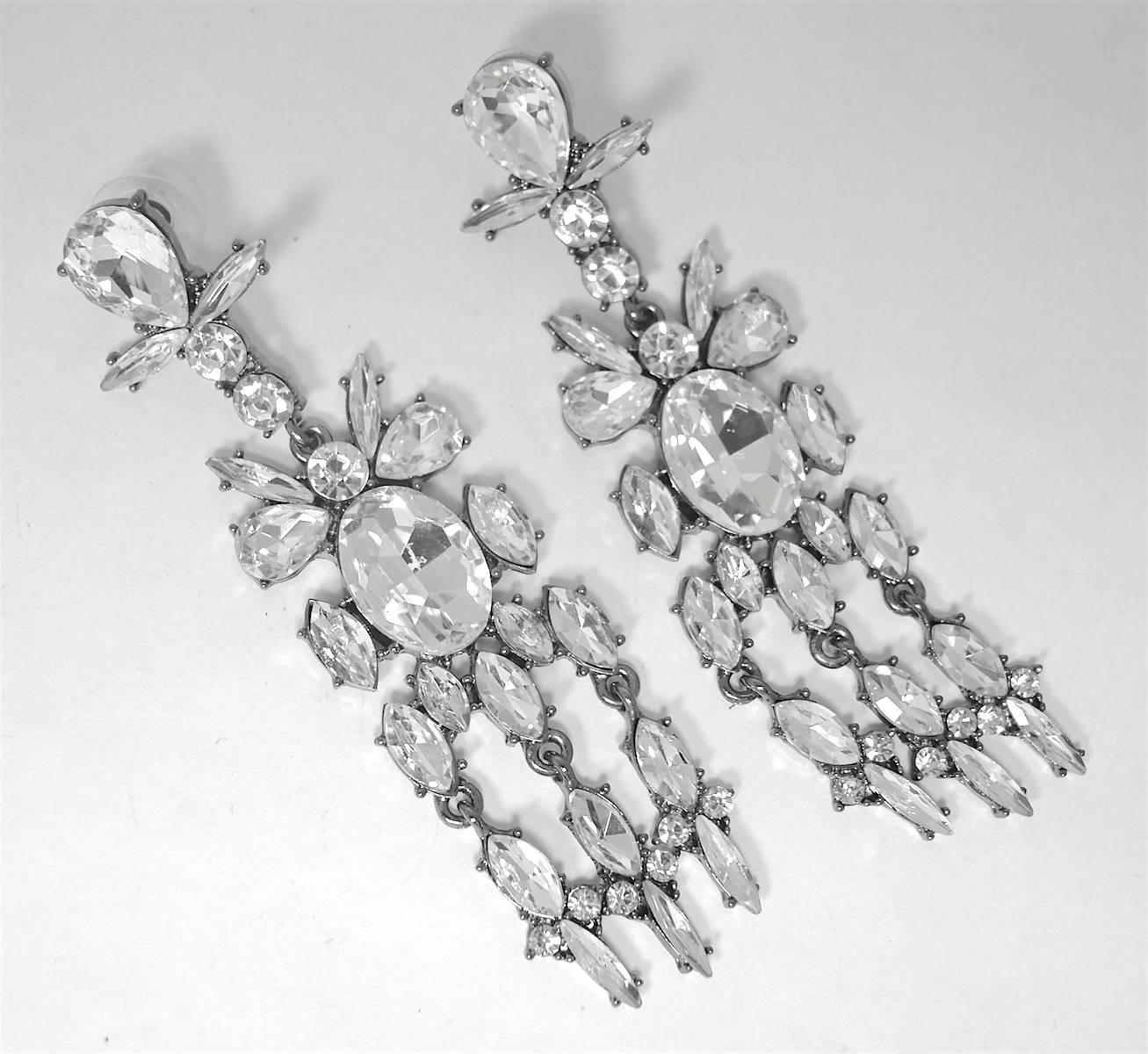 These pierced earrings were made with a rhinestone teardrop center and surrounded with marquise and round rhinestones. They are prong set and measure almost a whopping 4” x 1”. They are set in a silver tone setting and are in excellent condition.   