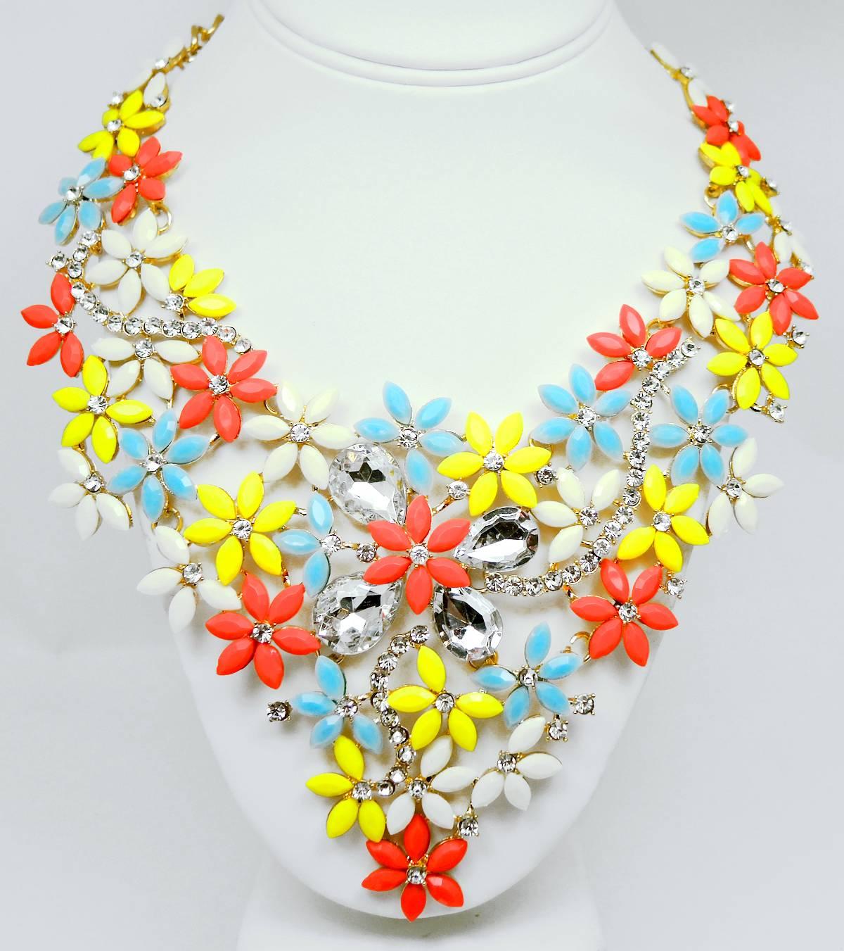 This is a very pretty fun floral necklace that has pink, white, yellow and blue flowers. It is designed with rhinestone accents and is in a gold tone setting with a lobster clasp. It measures 24” x 4-1/2” at the drop. It is in excellent condition.