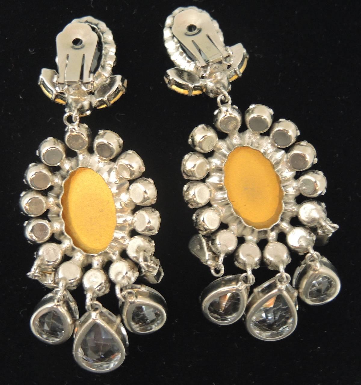These are well made earrings and are elegant as well as a real showstopper. They are made with clear crystals with dangling teardrop crystals at the bottom. They are in a silver tone setting and measure 3-1/2” x 1-1/2” and are in excellent condition.