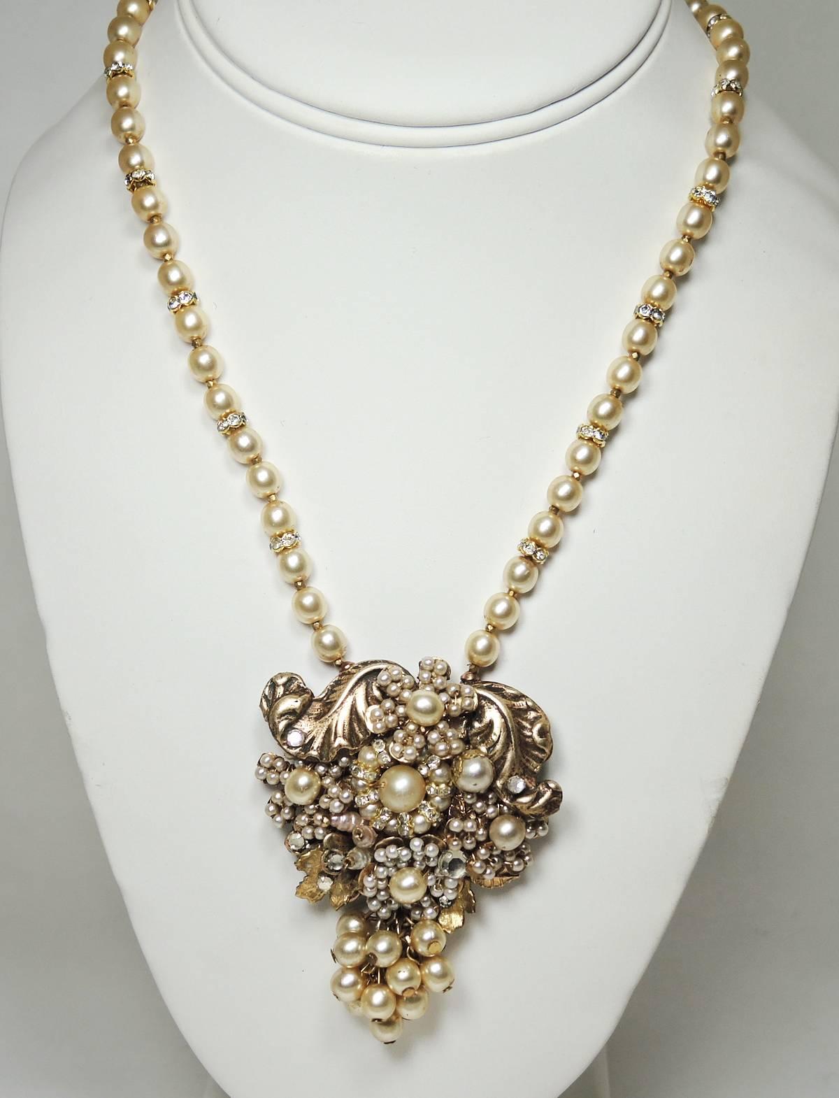 Here is a beautiful, all original, vintage necklace by Miriam Haskell that is artfully crafted with a large ornate drop.  It is embellished with lustrous faux pearls, rose montee stones and golden leaves. It has a cluster of faux pearls at the base