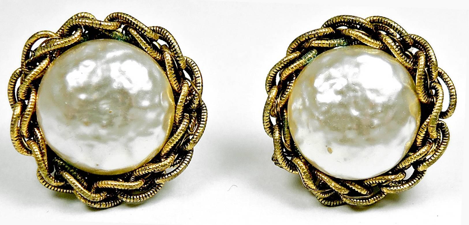 These are a pair of classic Miriam Haskell clip faux pearl button earrings. They are in an ornate braided brass tone setting and measure 1” x 1”. They are signed “Miriam Haskell” and are in excellent condition.