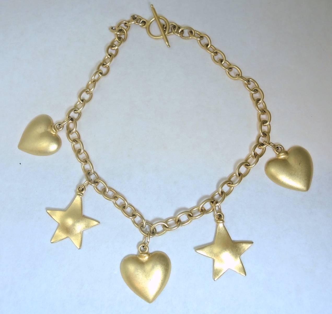 This is not signed but it makes me think immediately of Robert Lee Morris.  This very fun necklace has alternating hearts and stars that add up to five charms. These large sized charms dangle from a gold tone link chain. It has a toggle closure and