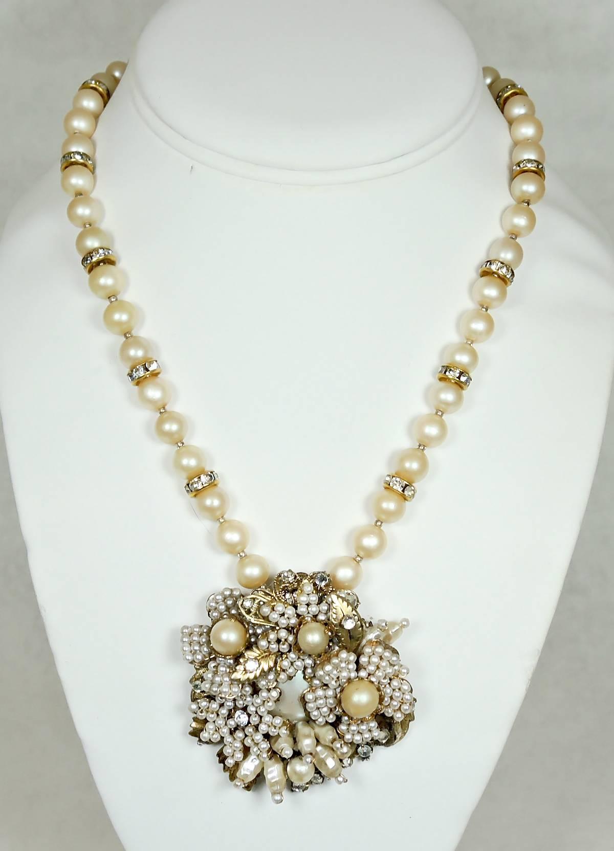 This lovely vintage 1950s Miriam Haskell necklace has cream color faux pearls accented with rhondelle spacers.  The necklace leads down to a beautiful centerpiece that has detailed floral faux seed pearls with golden flowers with three round faux