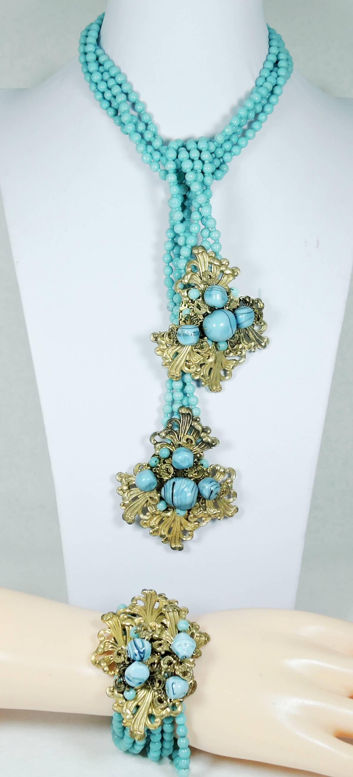 This is an exquisite, fabulous Miriam Haskell lariat necklace that was made with four strands of the signature hand wired faux turquoise beads that Haskell is known for. Each end has a dress clip. The gold tone hardware on the clip part has wired