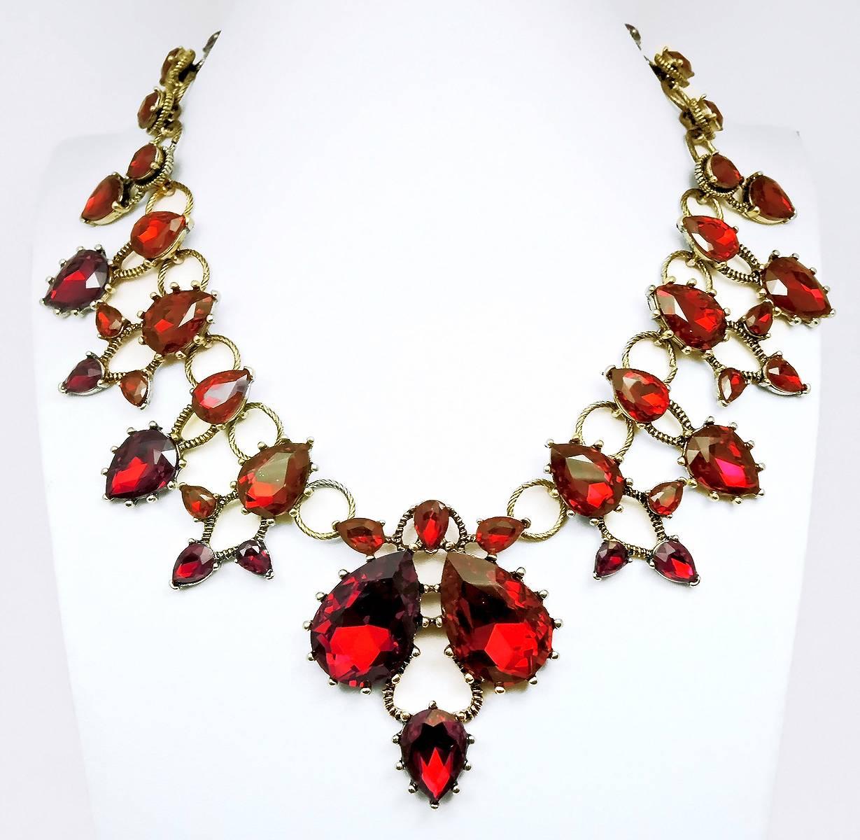 This is an outstanding Oscar De La Renta necklace!  It is designed with absolutely gorgeous teardrop shaped faux rubies. All the stones are prong set. This necklace is made in a brass tone setting and has a lobster clasp. It measures 18” x 1-3/8”.