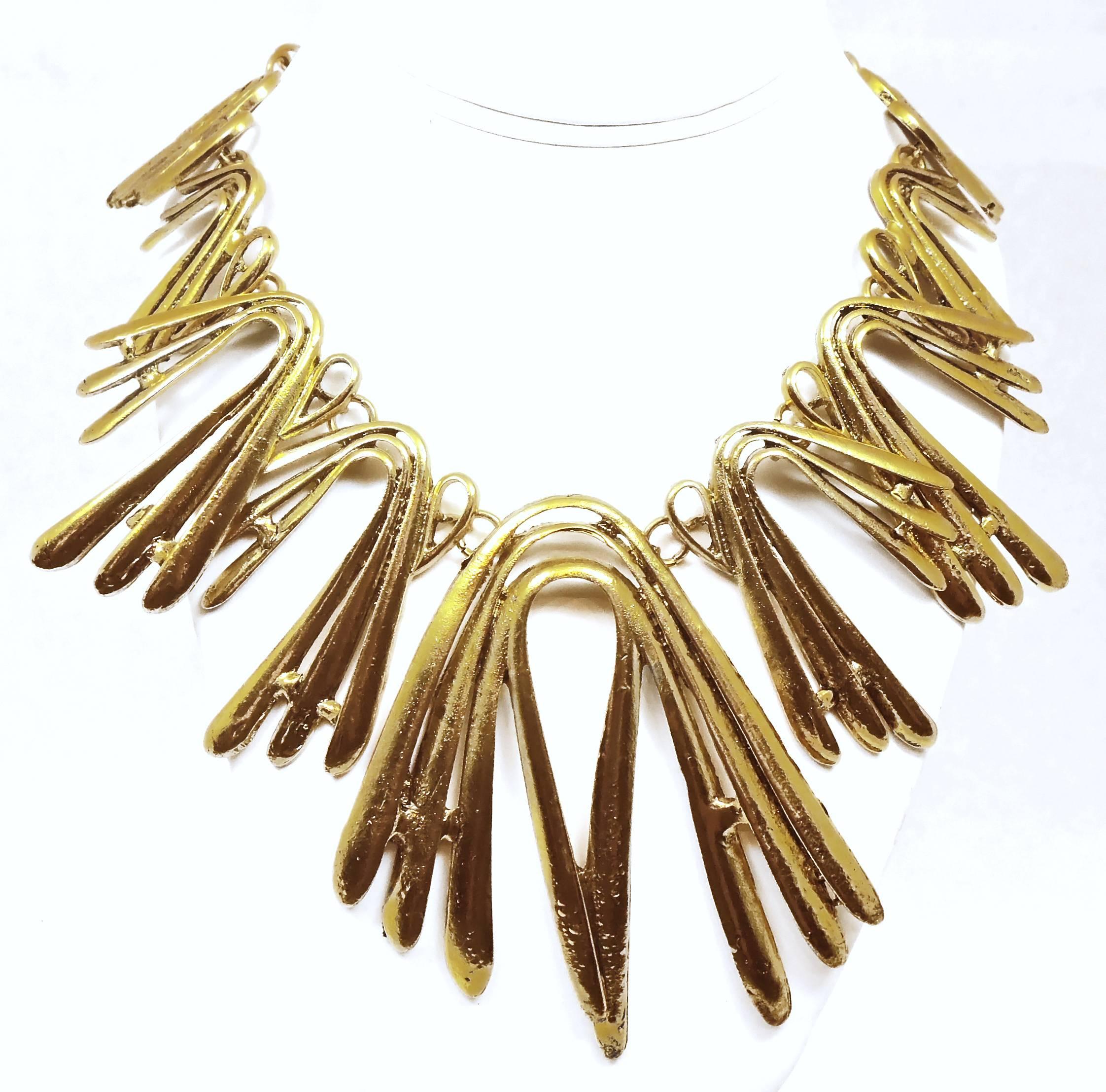 This very much in demand Oscar De La Renta necklace  is bent and shaped to look like gentle spikes. It is made in a gold tone setting and has a lobster clasp and measures 19” x 1/4”. The drop from top to bottom measures 4” x 3”.  It is signed “Oscar