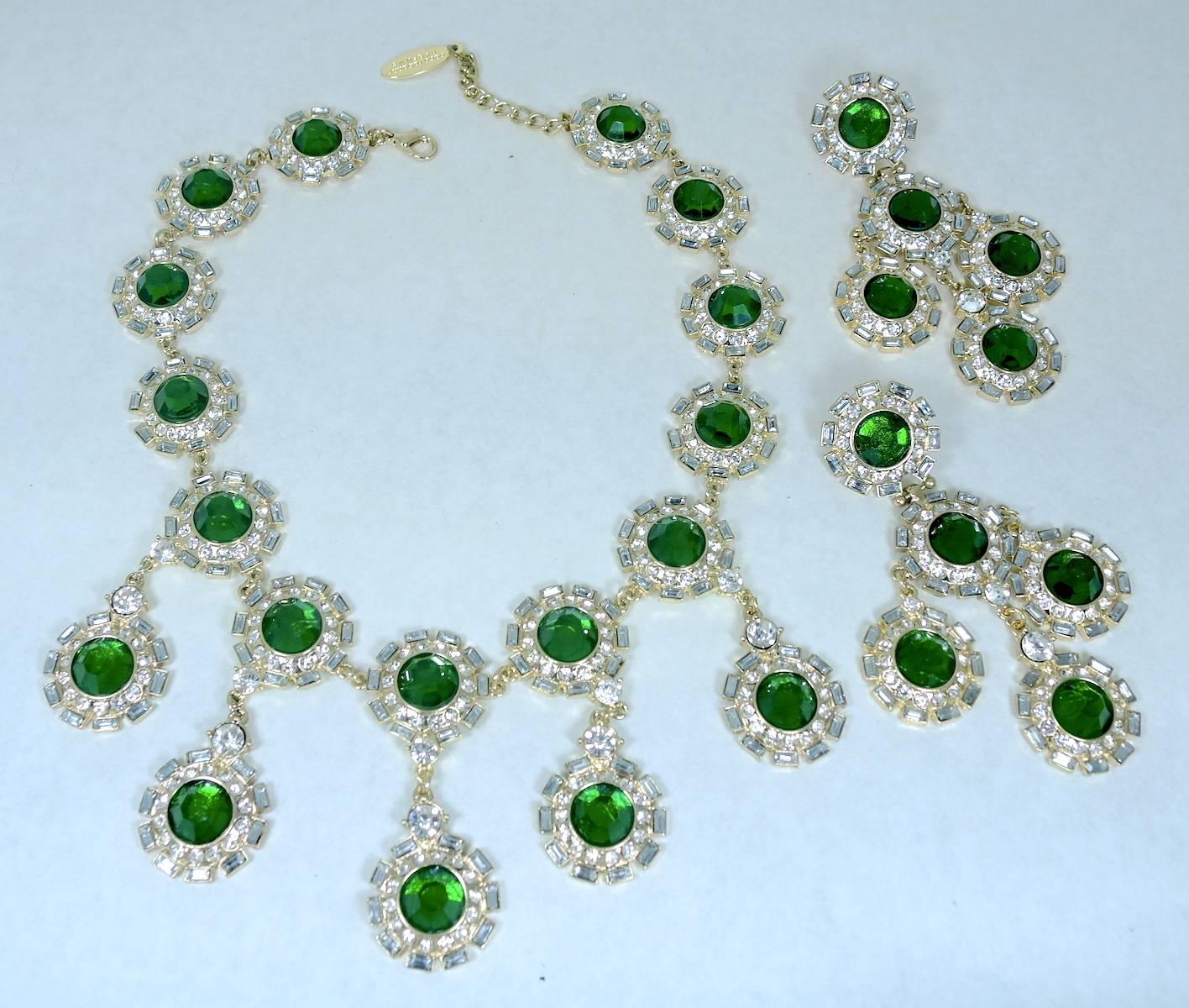 This spectacular runway necklace was made by Paco Rabanne and features a creative design of thirteen alternating round discs with brilliant faux emeralds in the center. They are framed by gorgeous crystal accents. The disks have a look like