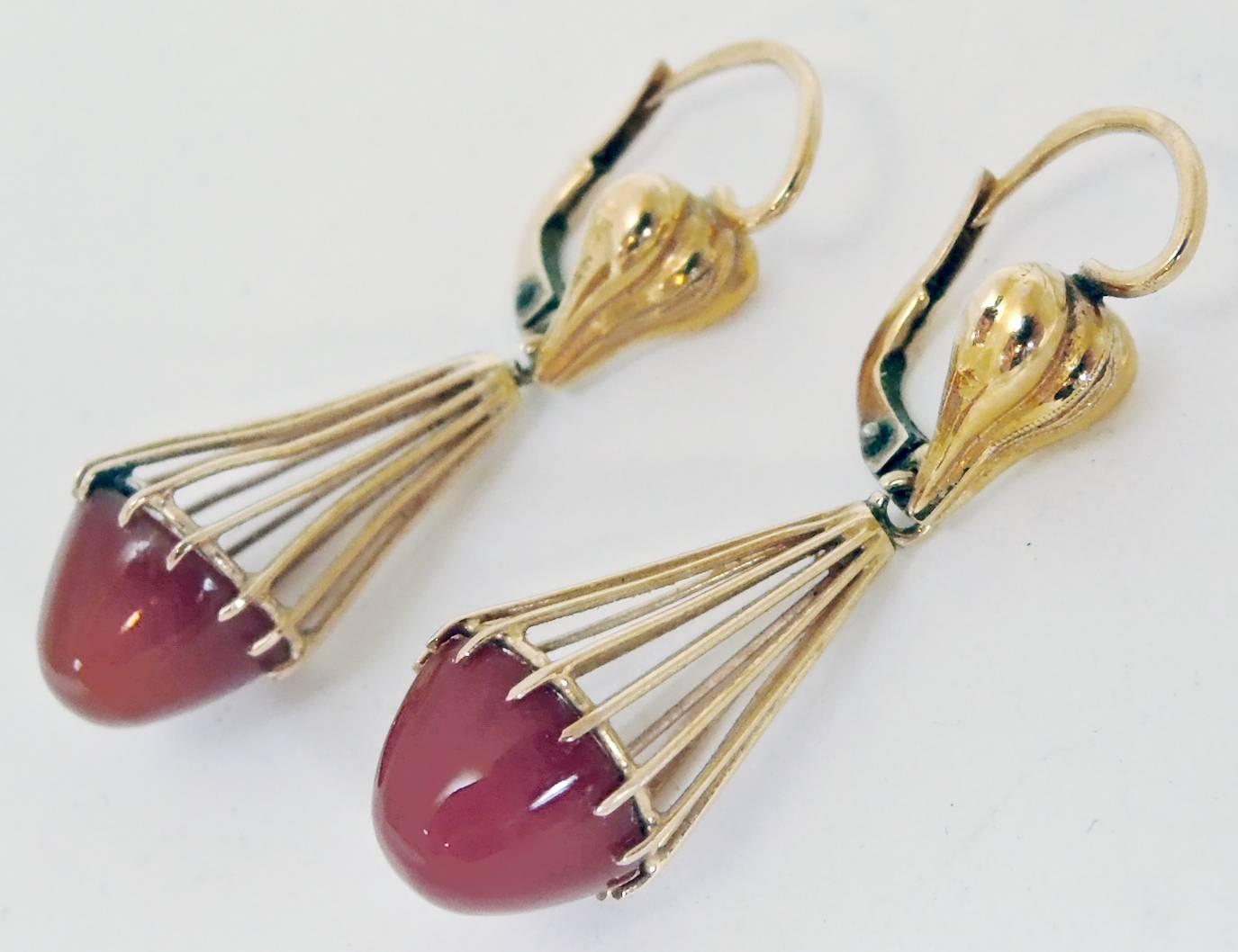 These 18kt gold clip earrings feature a bullet style carnelian stone.  It is prong set and has a cage design. It is made of 18kt gold and measures 1-1/2” x 1/2”. It is in excellent condition.