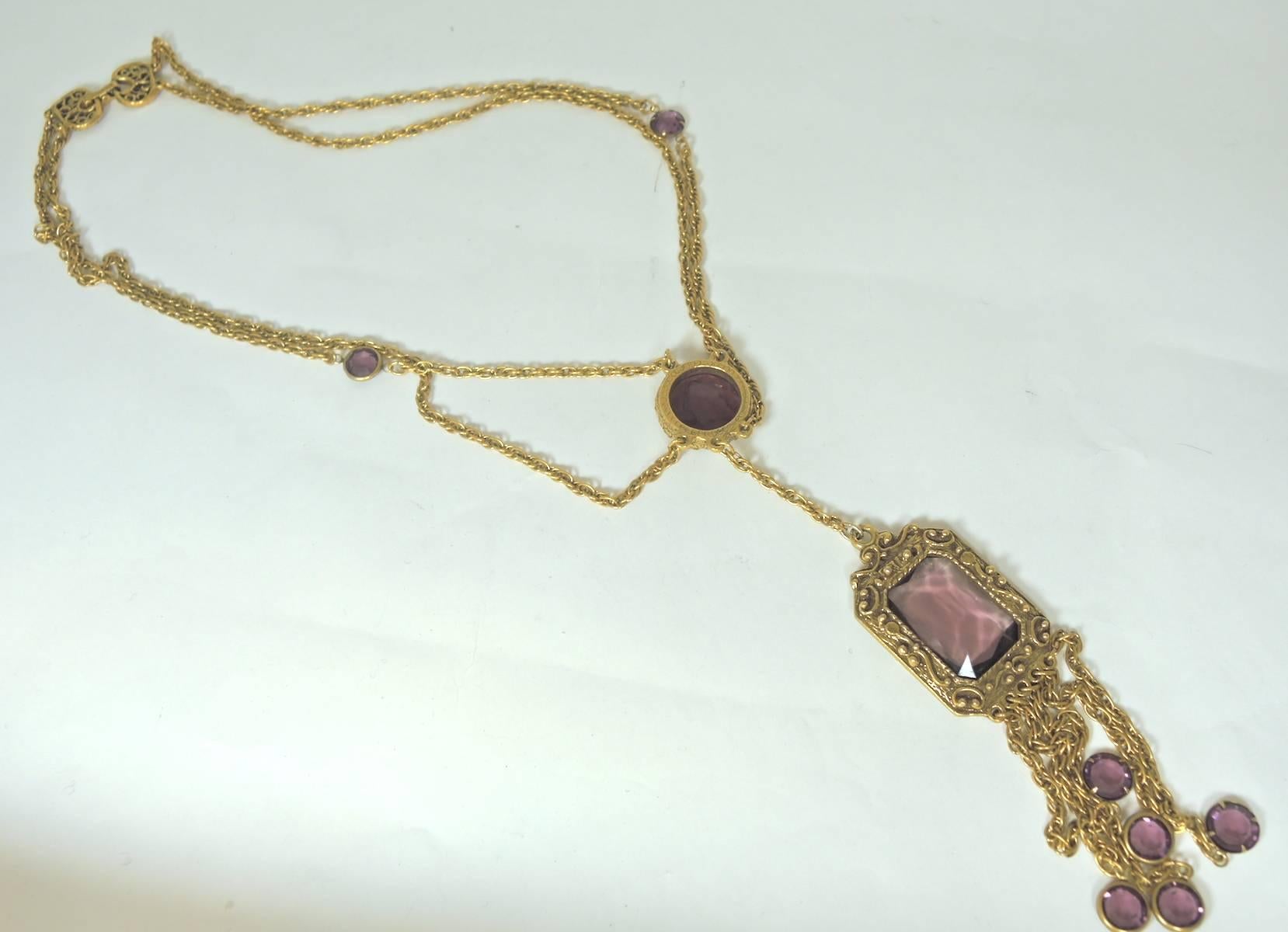 This exquisite vintage necklace is very unusual. It features a double rope chain that swags to create a chatelaine. It has two faceted and prong set amethyst stones halfway down one of the necklaces. The necklace leads to a lovely intaglio glass