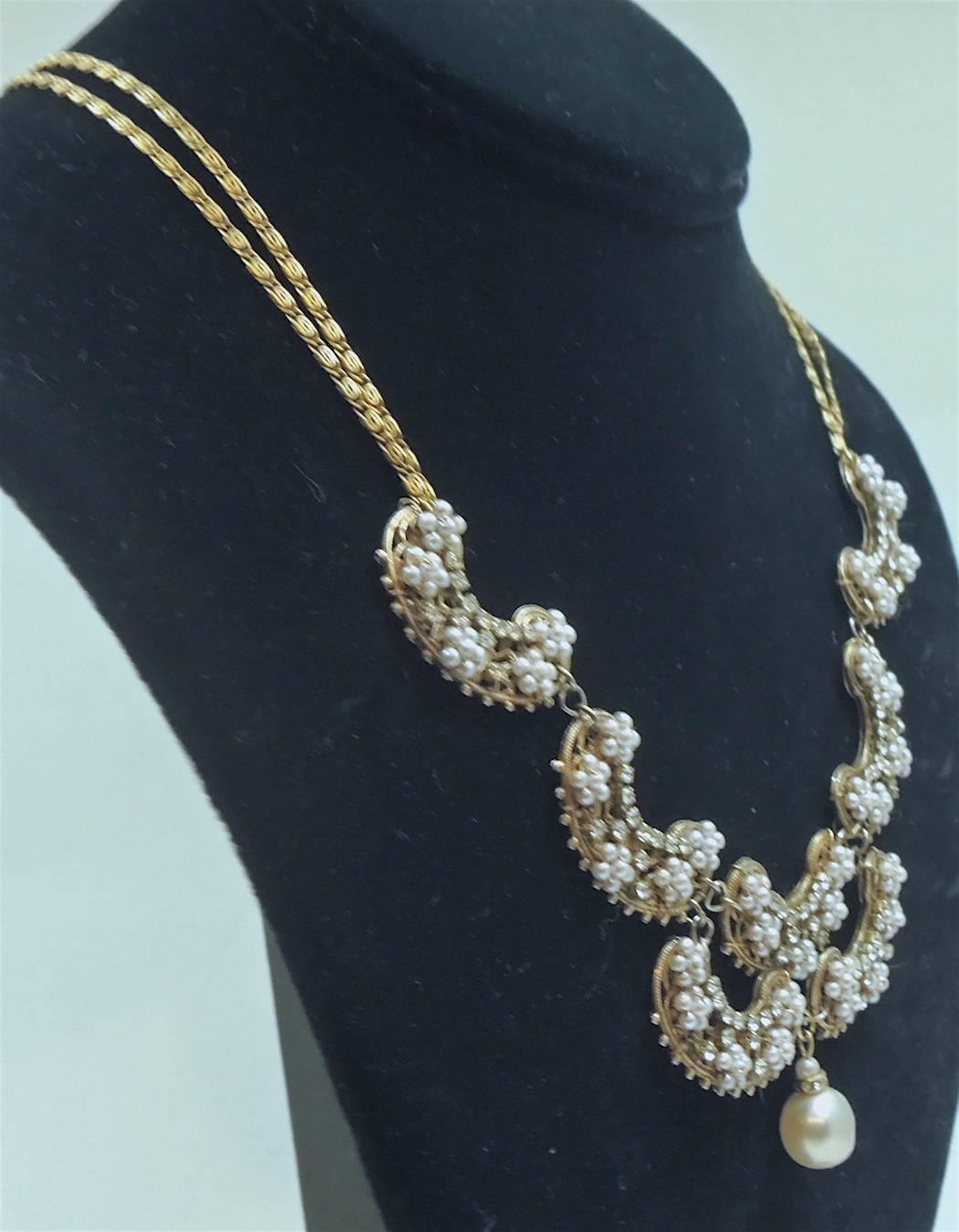This Miriam Haskell necklace was made in the 1930s before Haskell signed her jewelry and is highly collectible. It has a double chain that leads to seven scallops connected to each other. Each scallop has clusters of seed pearls and rose montee