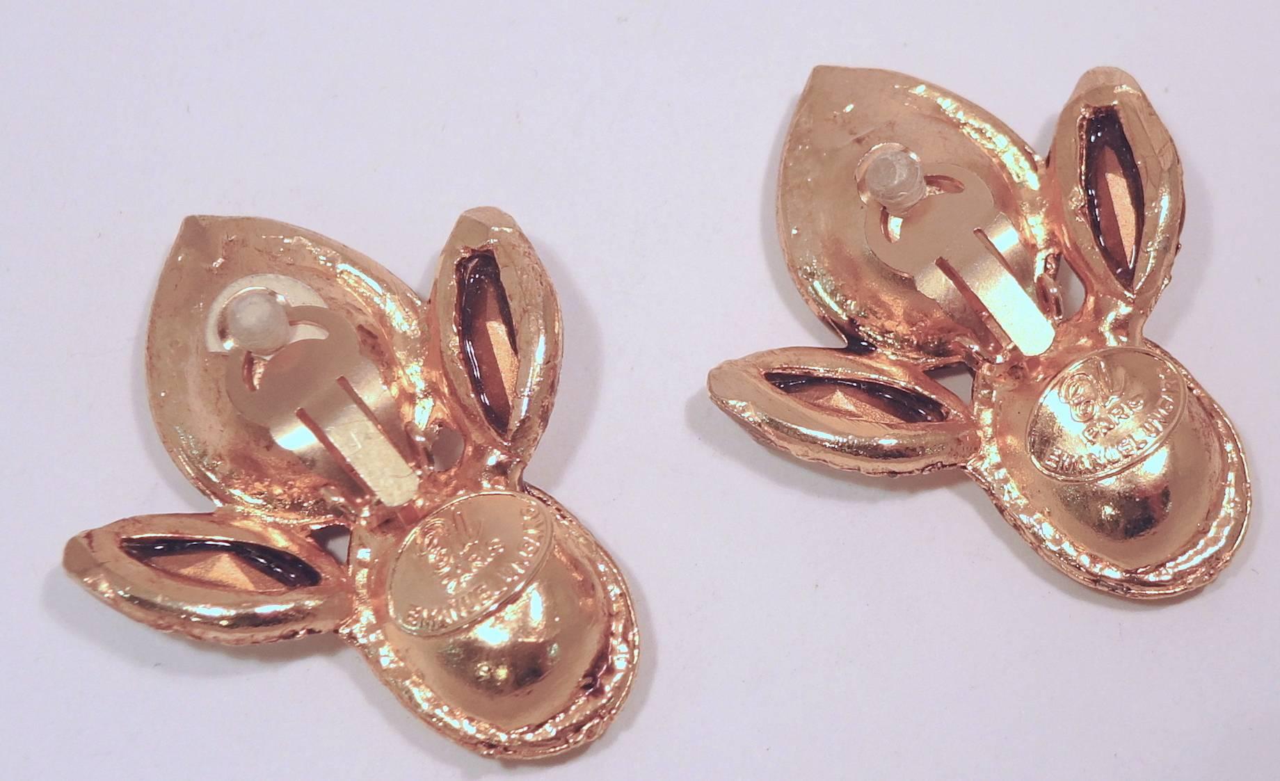 These beautiful clip earrings by Emanuel Ungaro are designed with four crystals embedded in gold tone frames. They measure 2-1/4” x 1-3/8” and are signed “Emanuel Ungaro Paris”. They are in excellent condition.