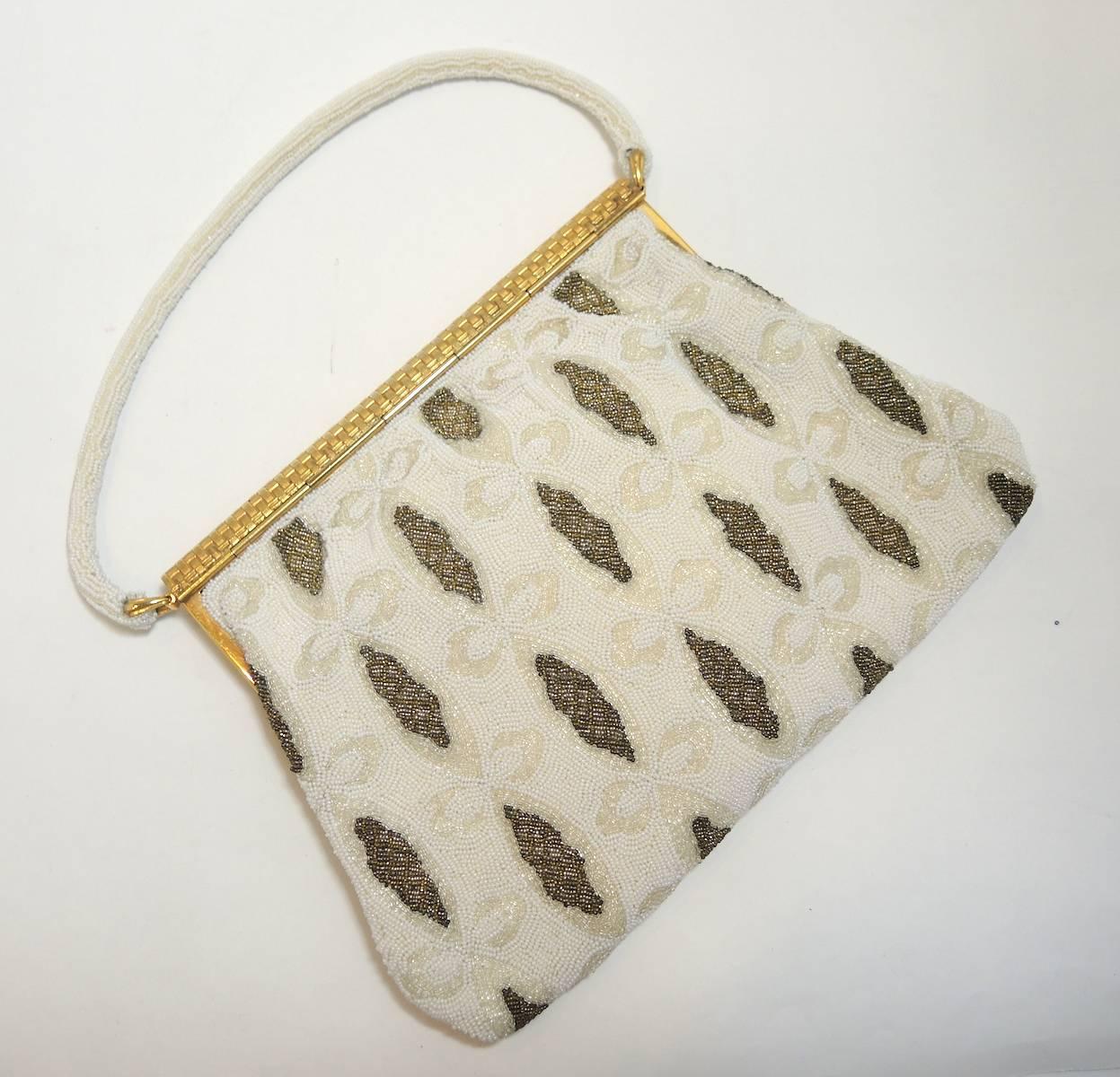 This stunning 1940s evening bag is in mint condition and is immaculately clean. Entire body is in white and gold small steel beads with a gold diamond shaped design on both sides. The gold tone flap has a basket weave design with rhinestones in the