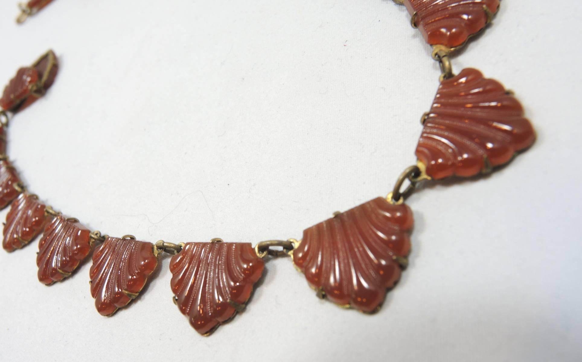 This 1930’s necklace is a classic design from the Deco period! It has nineteen seashell shaped carnelian stones hanging from a brass link chain.  It has a spring ring clasp and measures 15” x 1/2”.  It is in excellent condition.