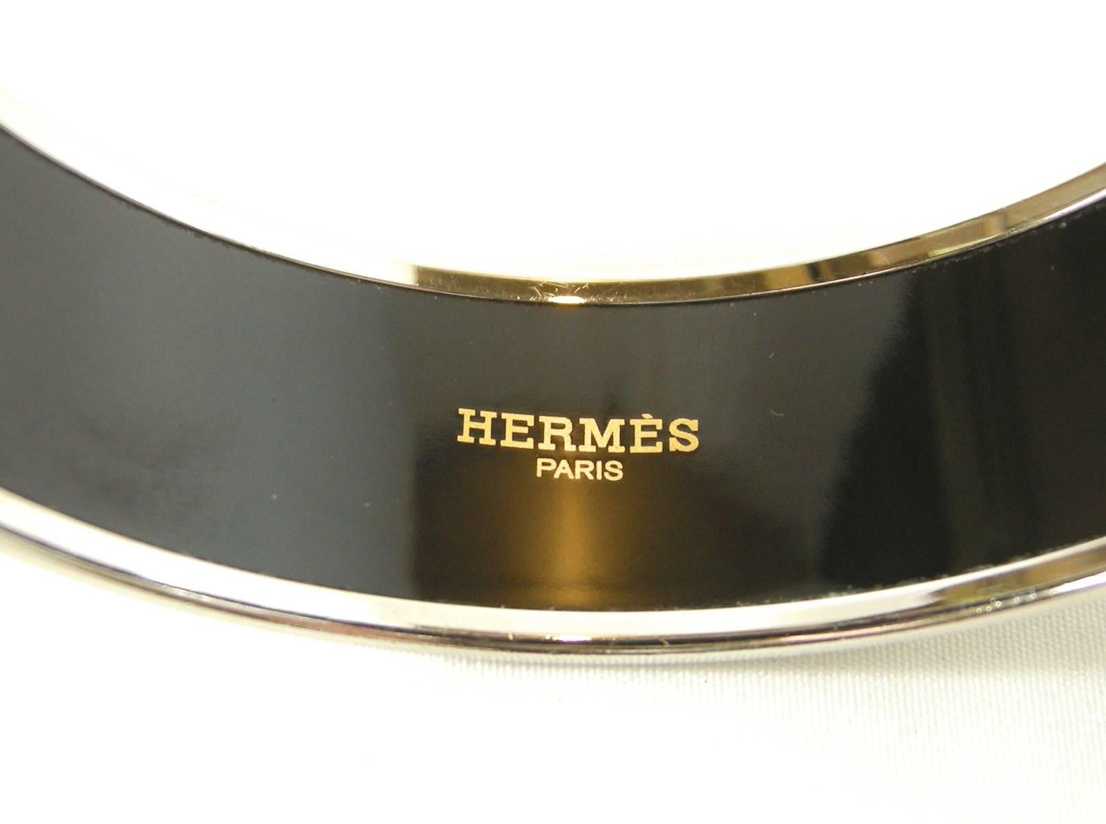 This is a stunning Hermes enamel bangle.  This bracelet color is a predominantly lime green color with white, yellow, and rust colored in intricate designs. This bracelet measures 3/4
