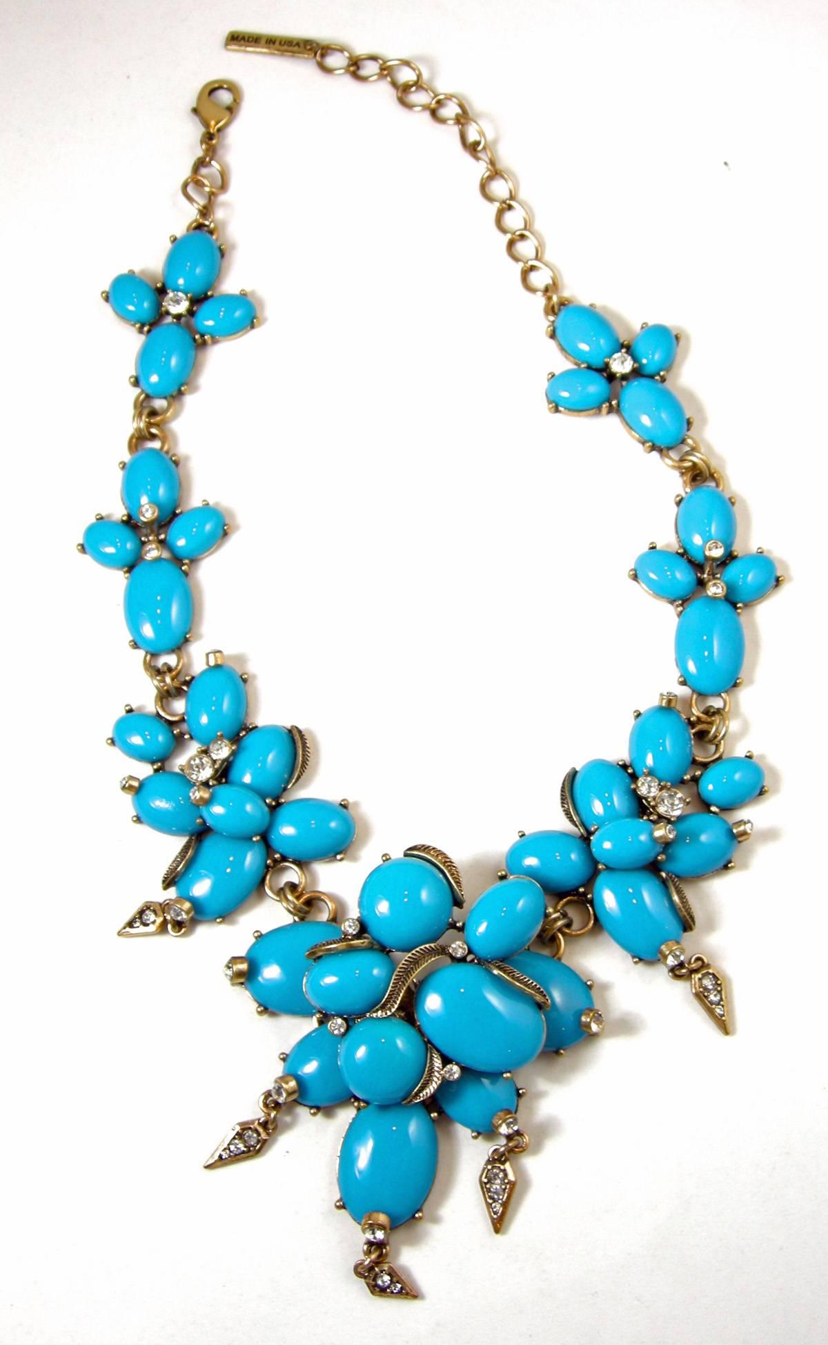 This is an Oscar De La Renta Necklace that is massive and makes a statement! It has large oval turquoise enamel cabochons set in clusters. The largest center link has layered ovals with thick gold wires in between tipped with clear rhinestones. The