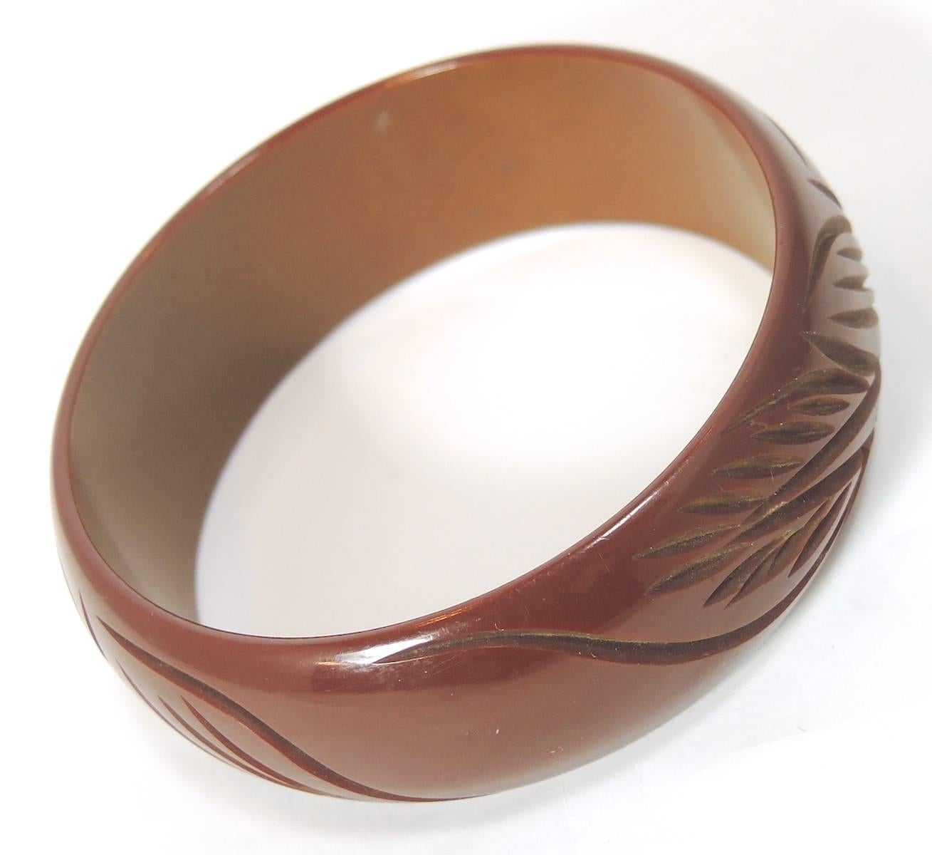 This vintage bangle bracelet features a carved design in brown Bakelite. This bracelet measures 9” x 1” and is in excellent condition.