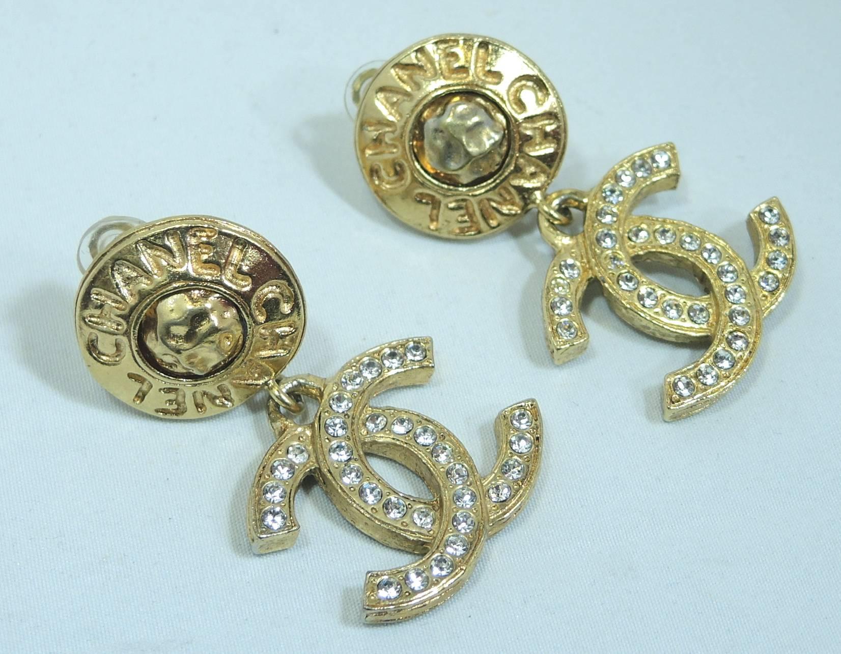 Whenever I find these earrings … I grab them. These authentic Chanel clip earrings have a round button top with the famous Chanel logo. The bottom part hangs down with the iconic double Cs motif embedded with crystals. They have a gold tone setting