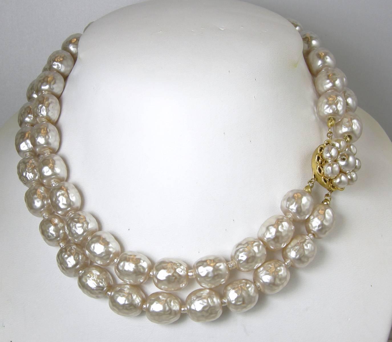 This is a majestic Miriam Haskell double strand necklace from the early 1950s. It is all-original with no repairs. The faux baroque pearls are luminous and are in excellent condition. It has a floral side in clasp and measures 16” x 1/2”. It is in a