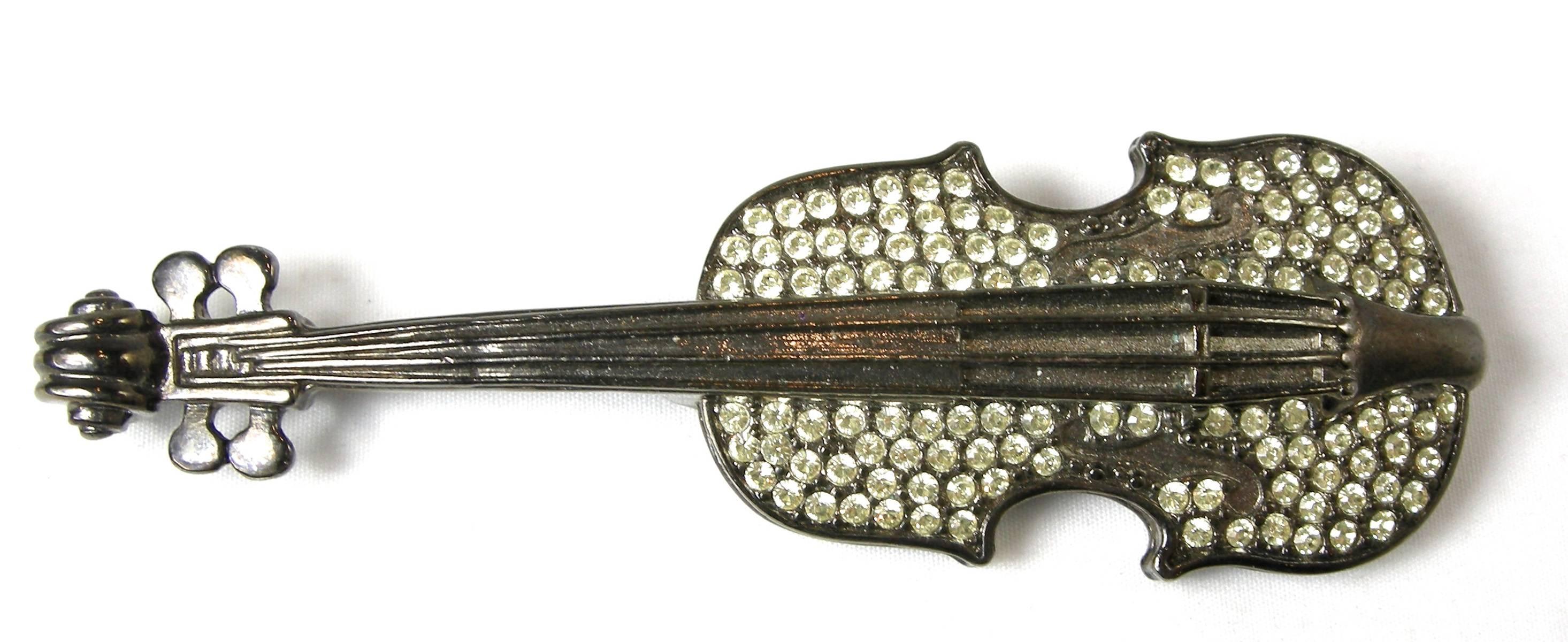 This 1970s rare and famous brooch was designed by Givenchy and features a violin studded with beautiful rhinestones in a gunmetal setting. It measures 4” x 1-1/2” and is signed “Givenchy” with the famous logo. It is in excellent condition.