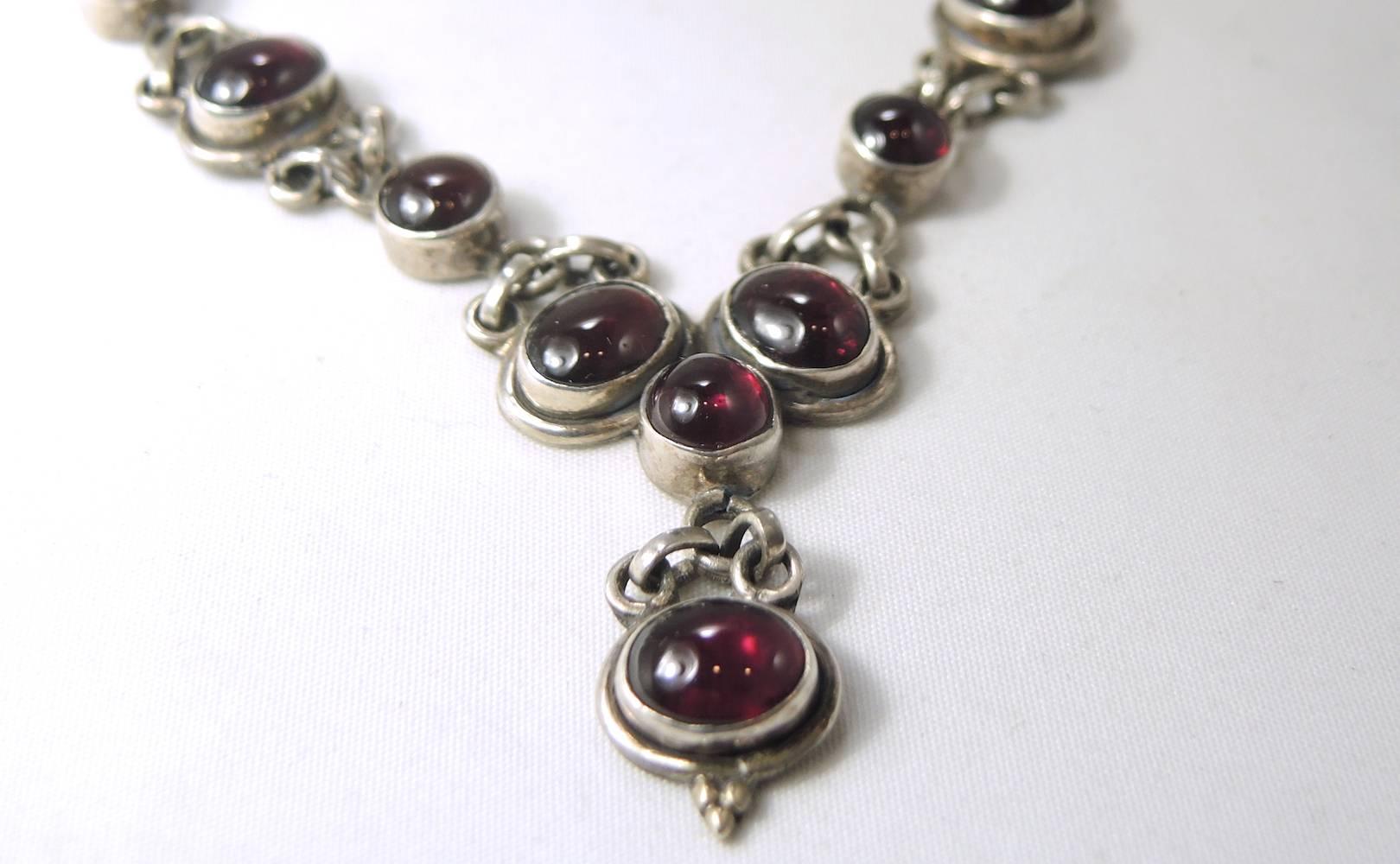 This beautiful set is made with oval garnet cabochons set into sterling silver bezels. The cabochons alternate from oval to round and lead down to the center dangling cabochons.  It has the old fashioned lobster clasp and measures 18” and the center