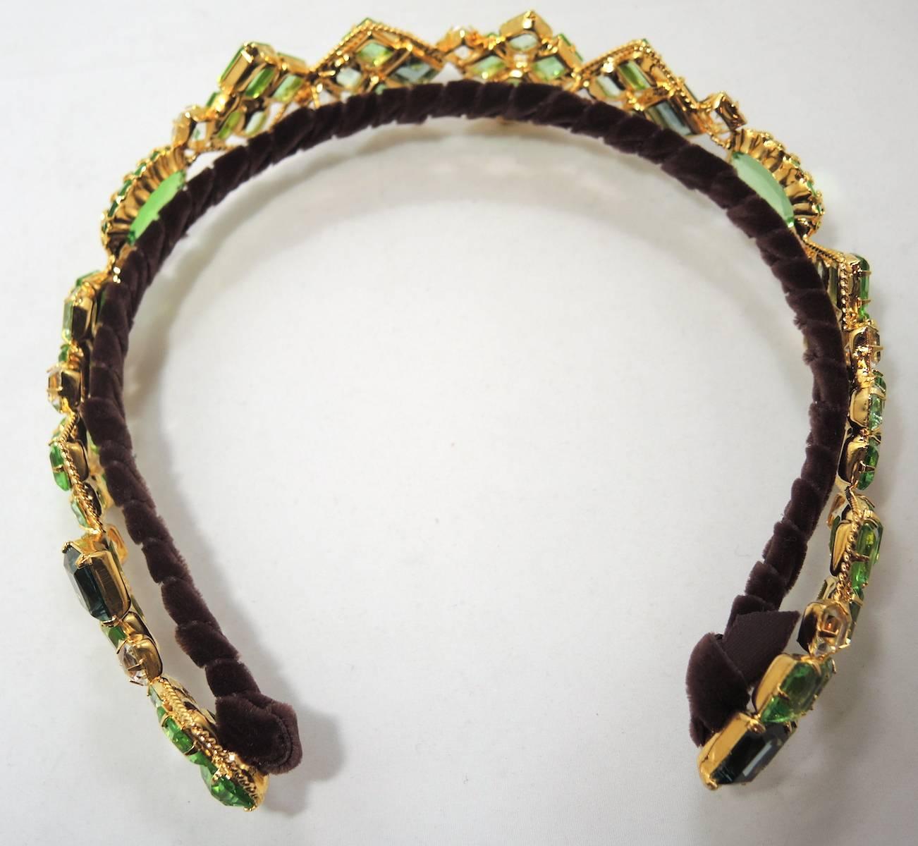 This is a one-of-a-kind headband designed by Robert Sorrell. The design is exquisite and perfect for day or night. It features multi-color crystals including faux Peridot and clear crystals. The headband is hand made in an abstract design and is