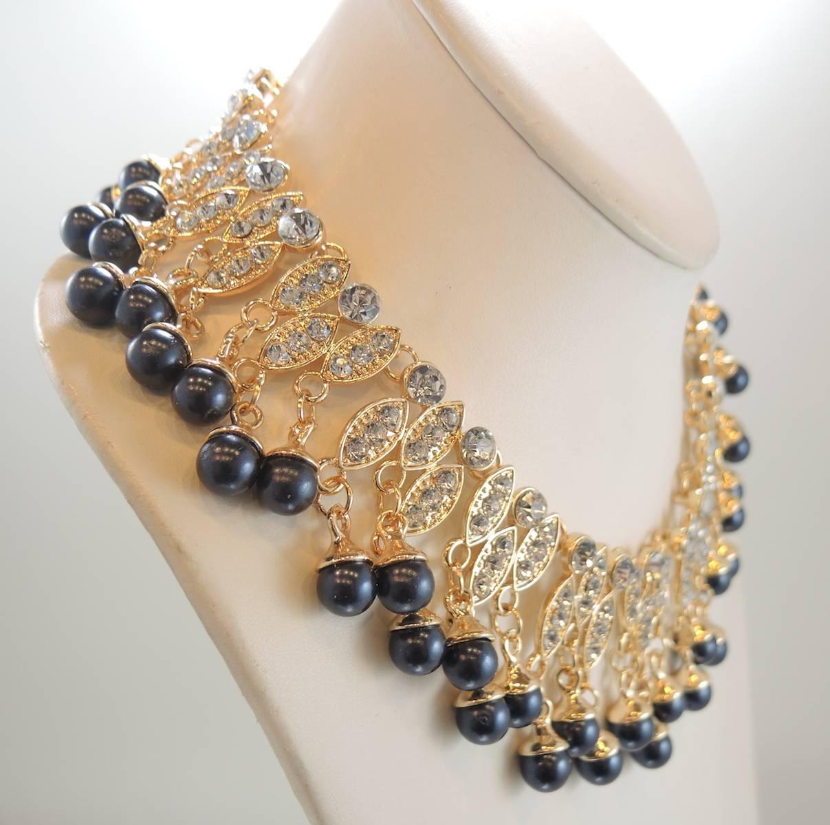 This beautiful collar necklace has sparkling marquis shaped gold tone drops with crystals embedded in its gold tone setting.  At the bottom of each drop are blue beads. It has a lobster clasp and measures 16-1/2” x 2”.  It is in excellent condition.
