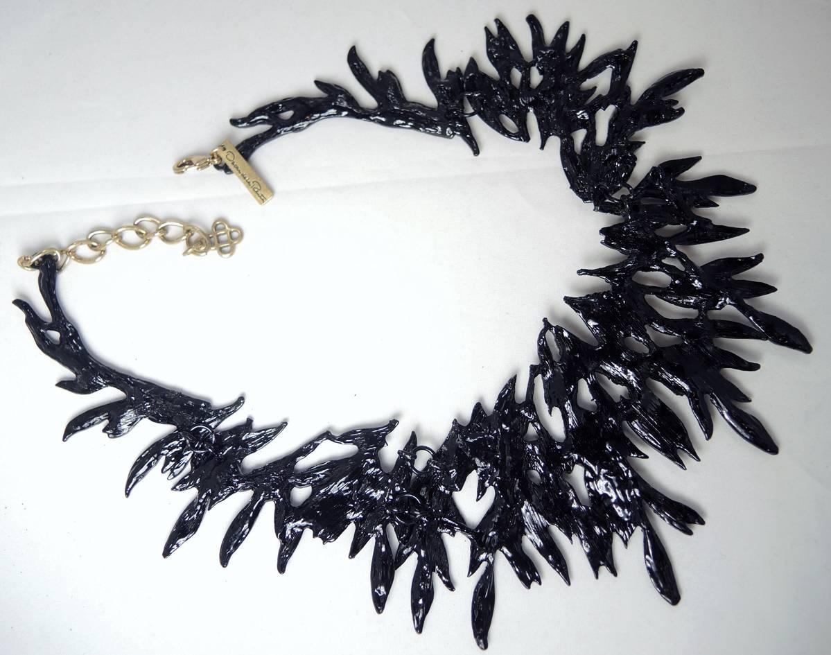 This necklace was designed by Oscar De La Renta and features a branch design made with black enamel branches. It has a lobster clasp and measures 16” x 3-1/4” at the widest part. It has a Japanned metal finish and is signed “Oscar De La Renta” “Made