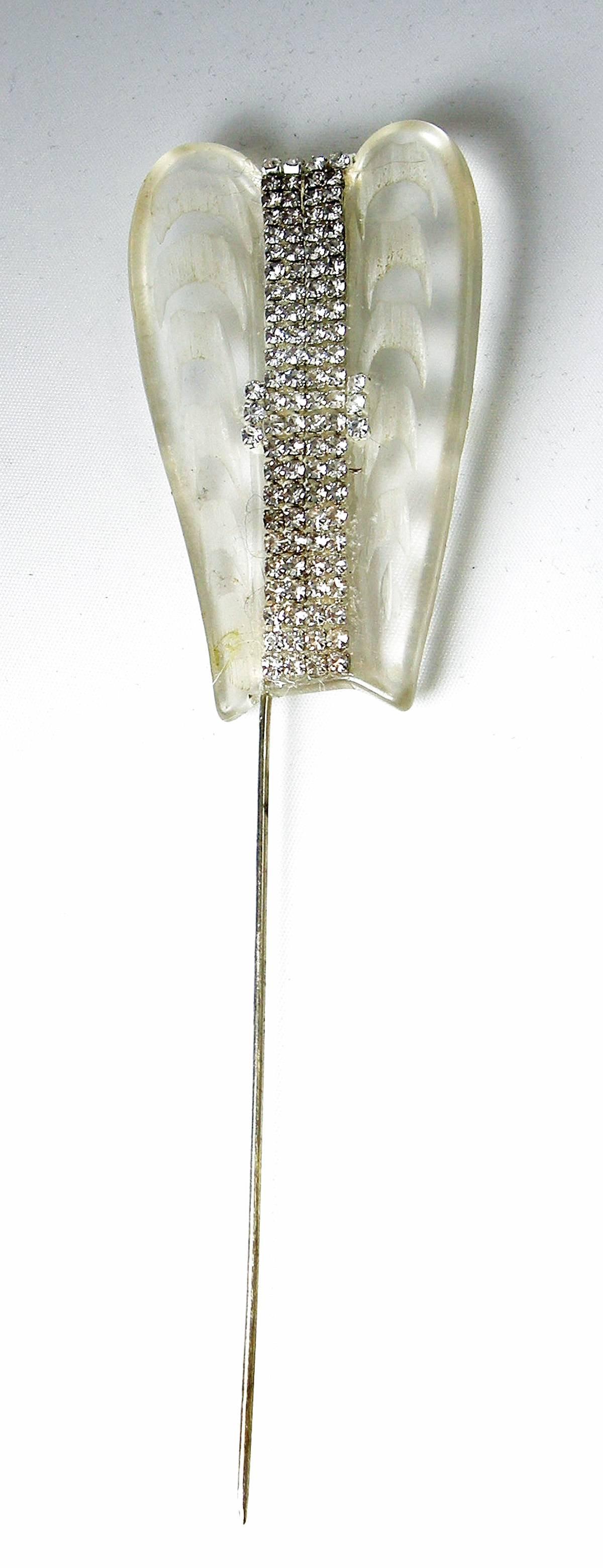 This is a special rare find of a Deco hat pin made of Celluloid with pave set rhinestones in the center. It is a classic deco design and calls your immediate attention.  This pin measures 5-1/2” x 1-1/2” and is in excellent condition.