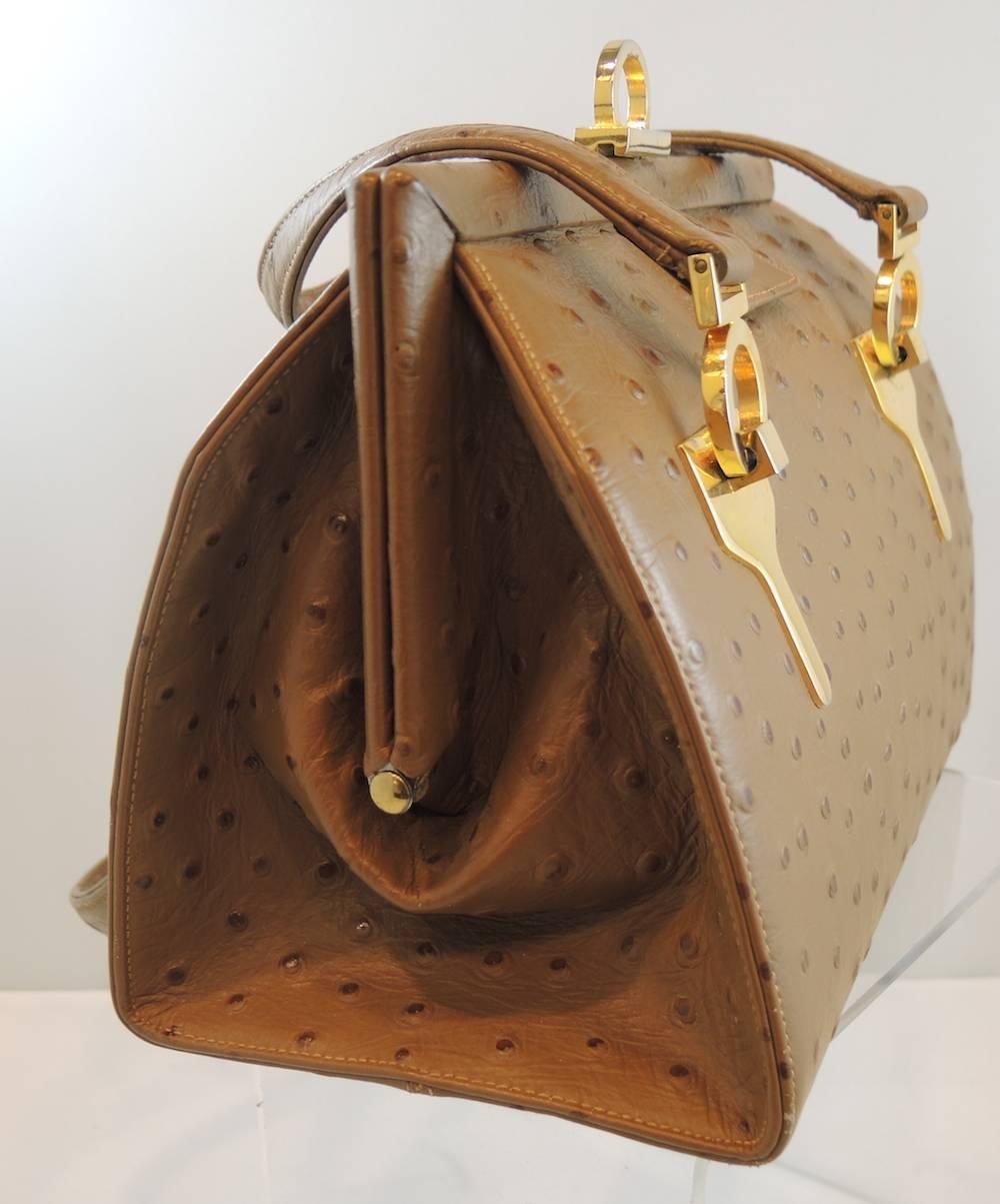 This bag is true vintage and is made of genuine full quill ostrich. It is light brown and has a gold tone hardware. The clasp is an easy twist one. The inside is made in a beautiful beige leather with a coin purse. The bag measures 8” wide x 6-1/2”
