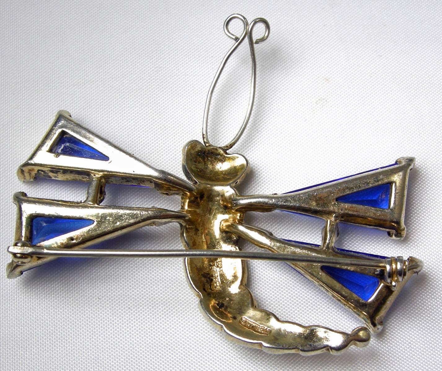 This is one of the most collectible Trifari’s from the 1940s.  It is sterling silver with a gold vermeil (some of the vermeil has faded, but does not take away the beauty of this piece at all.)  The blue glass wings of the dragonfly are triangular