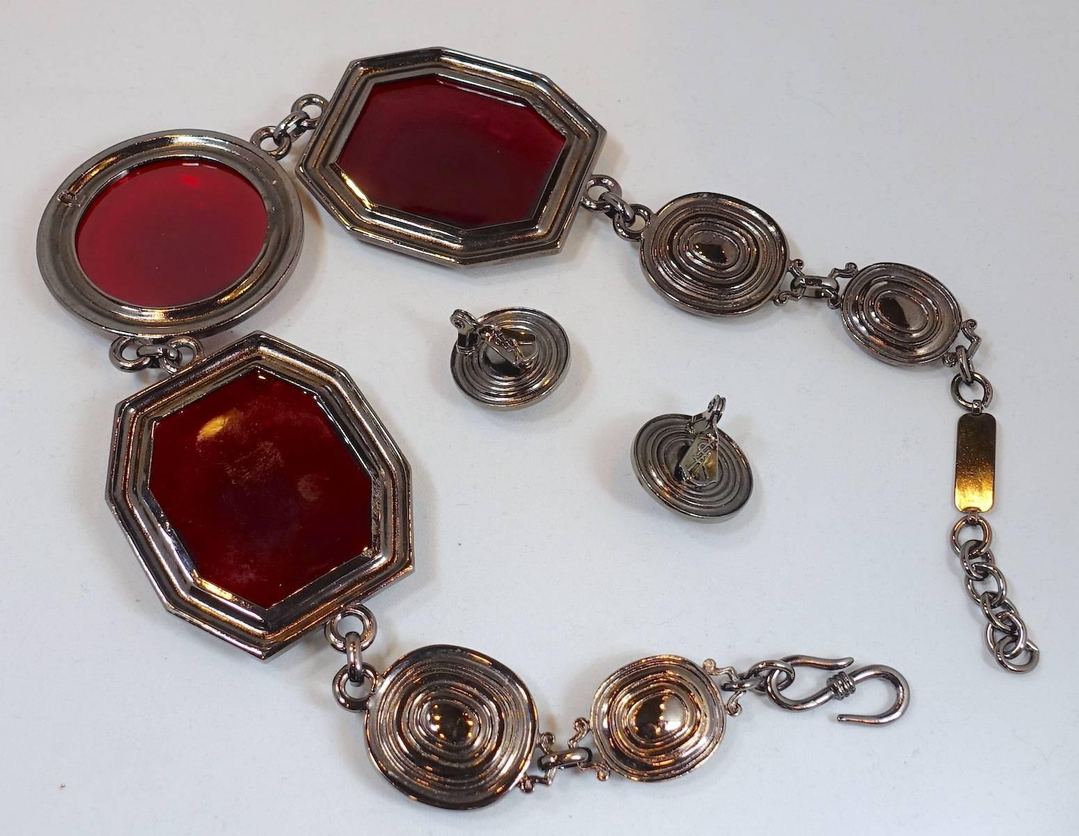 This is a fabulous couture runway vintage Yves Saint Laurent necklace and earring set. The necklace is made with octagon and round shaped red Gripoix glass embedded disks. It has a hook clasp and is in a pewter tone setting. It measures 21” in