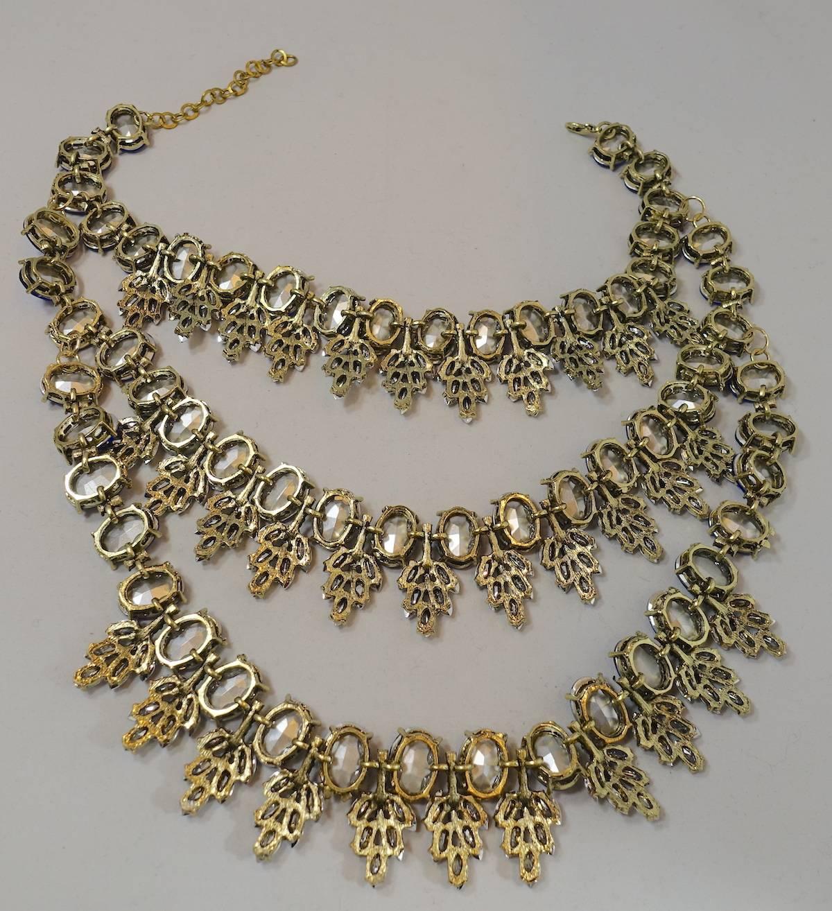 This is a massive cobalt blue & sparkling ice rhinestone drippy bib necklace.  It is dramatically gorgeous set in a gold tone metal finish with multi rows covered in cobalt blue and brilliant ice rhinestones. The blue stones are glass with