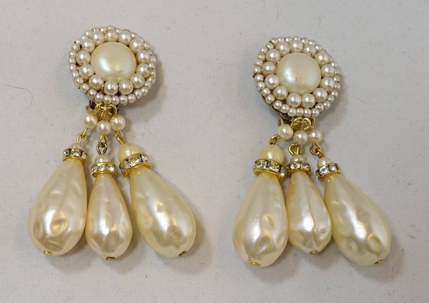 These earrings have a large baroque pearl in the center accented with smaller faux pearls and seed pearls. It has three large pearls that dangle at the bottom with a rose montee bead caps. These clip earrings are in a gold tone setting and measure