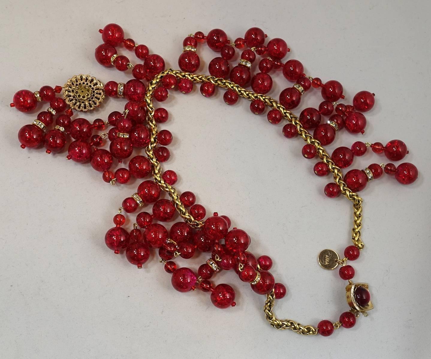 This fabulous bib necklace was designed by Anka.  It has rows of six dangling vintage red glass beads with rhondelle spacers to add an elegant touch. The center has a long red glass drop accentuated with a round ornate beaded glass that is