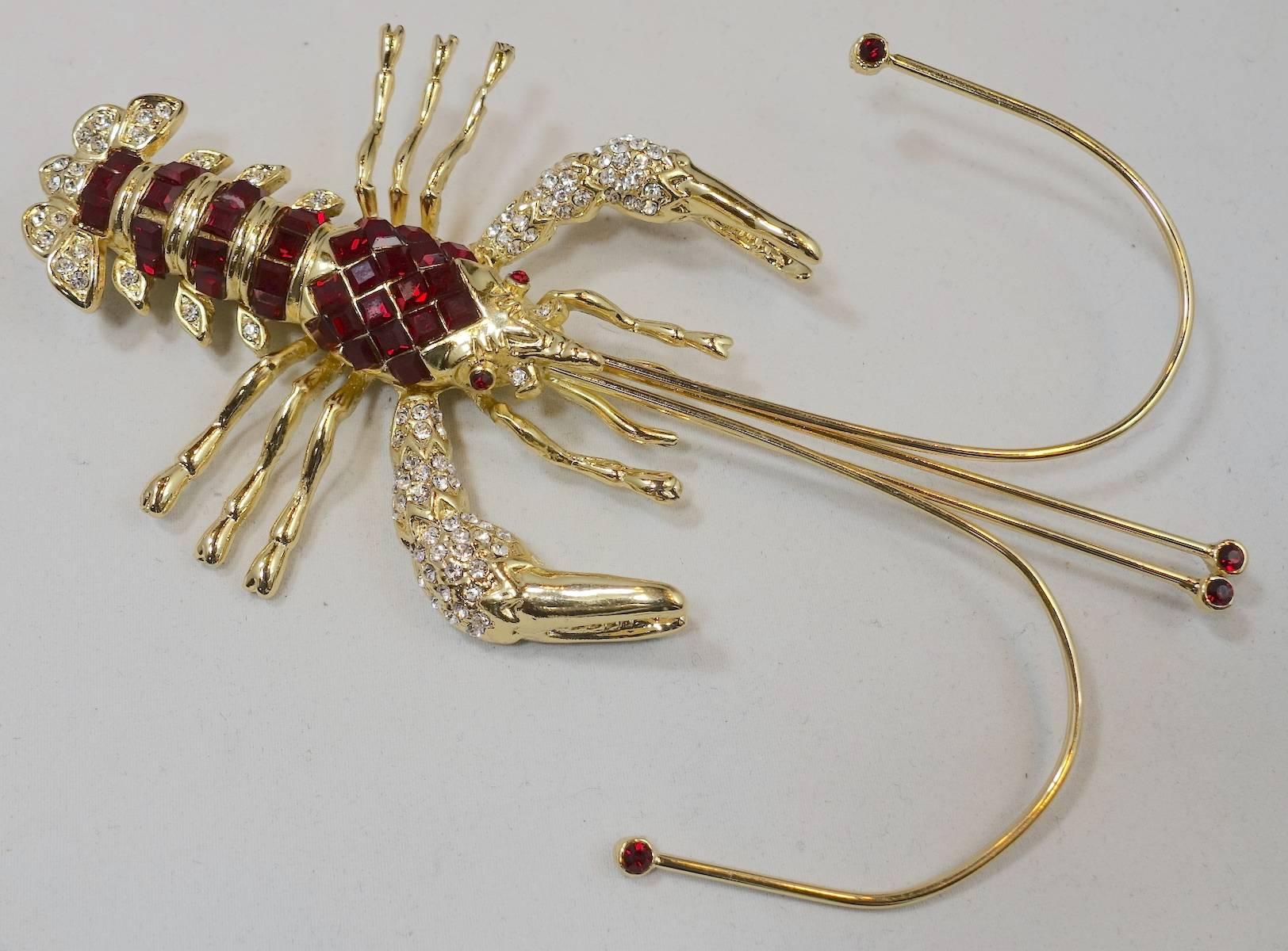 I love lobster pins and this is no exception. It is designed with red square inset rhinestones on the body. It is accented with clear crystals on the claws and tail. It is set in a gold tone metal finish and measures a whopping 6” x 4-1/4”. It is in