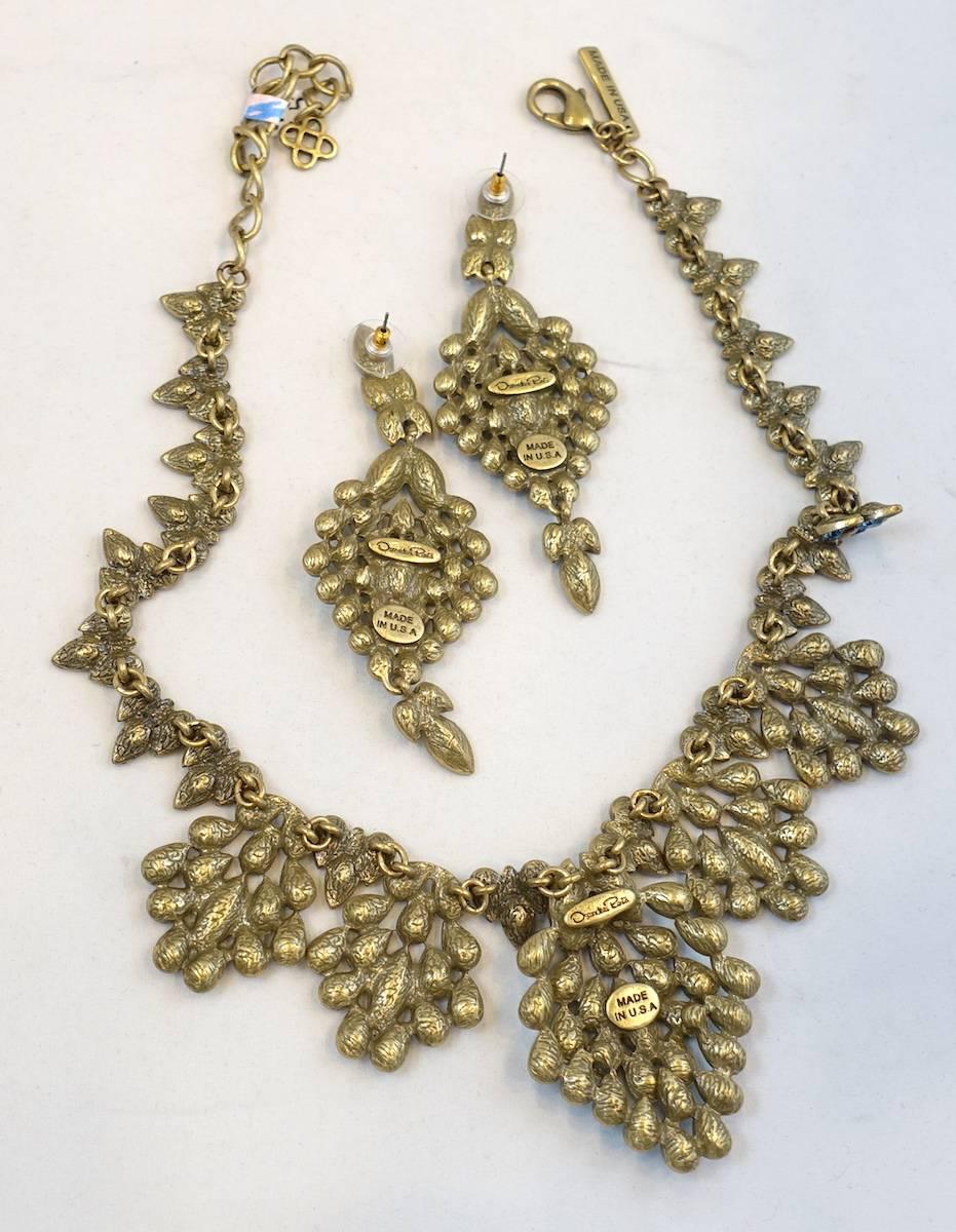This Oscar De La Renta necklace is so beautiful! All the colors create the peacock colors that eventually became the sets name.   It has five drops that dangle with large clusters of golden leaves. These leaves have sparkling peacock turquoise