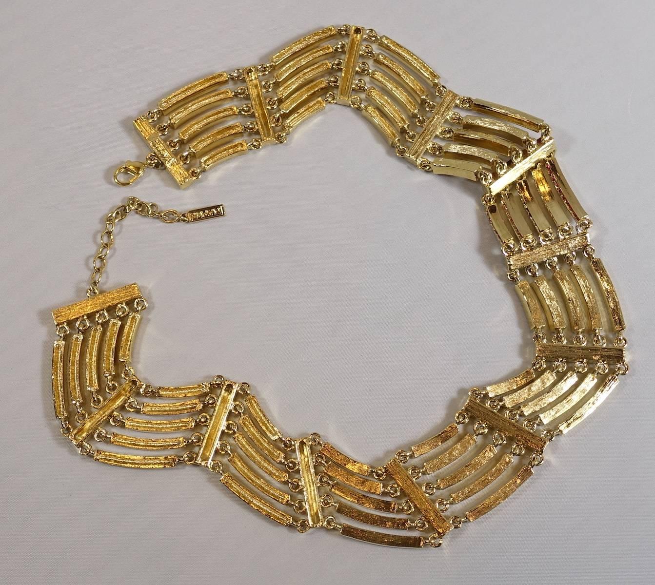 This vintage necklace features hues of pink and clear crystals in a gold tone setting.  The necklace has a lobster clasp and measures 15” x 1-1/4” and is signed “Napier”. It is in excellent condition.