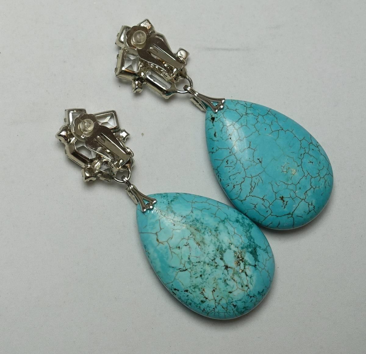 These one-of-a-kind earrings by Robert Sorrell feature faux turquoise stones with clear crystal accents in a silver tone setting.  These clip earrings measure 3-1/2” x 1-1/2” and are signed “Sorrell Originals”. These earrings are in excellent