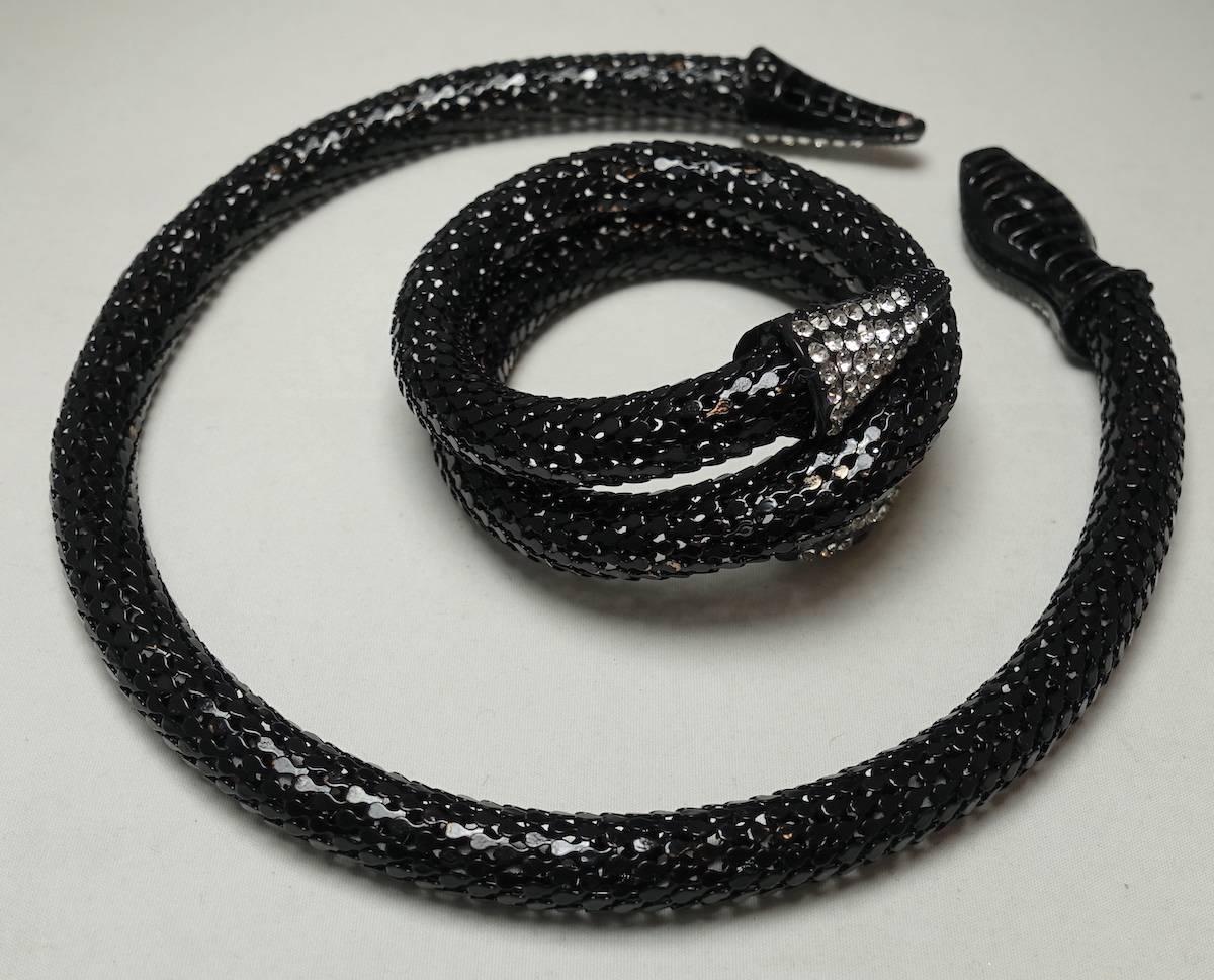 This flexible set features a snake-serpent design with clear crystal accents in a gunmetal setting.  The necklace measures 17” x 1/2”.  The bracelet can be worn on the wrist or arm and measures 18” x 1” when stretched out.  This fun set is in