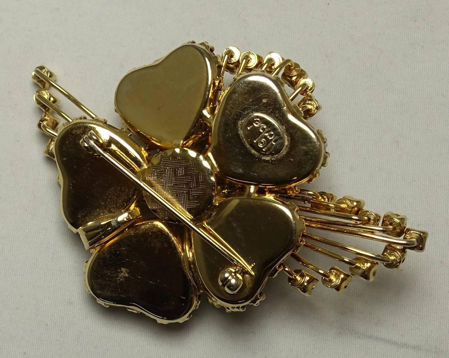 This is lovely1940s vintage seldom seen Hobe brooch. It is designed with five ice blue iridescent hearts accented with rhinestone borders in a gold tone setting. This brooch measures 3” x 2” and signed “Hobe”. It is in excellent condition.