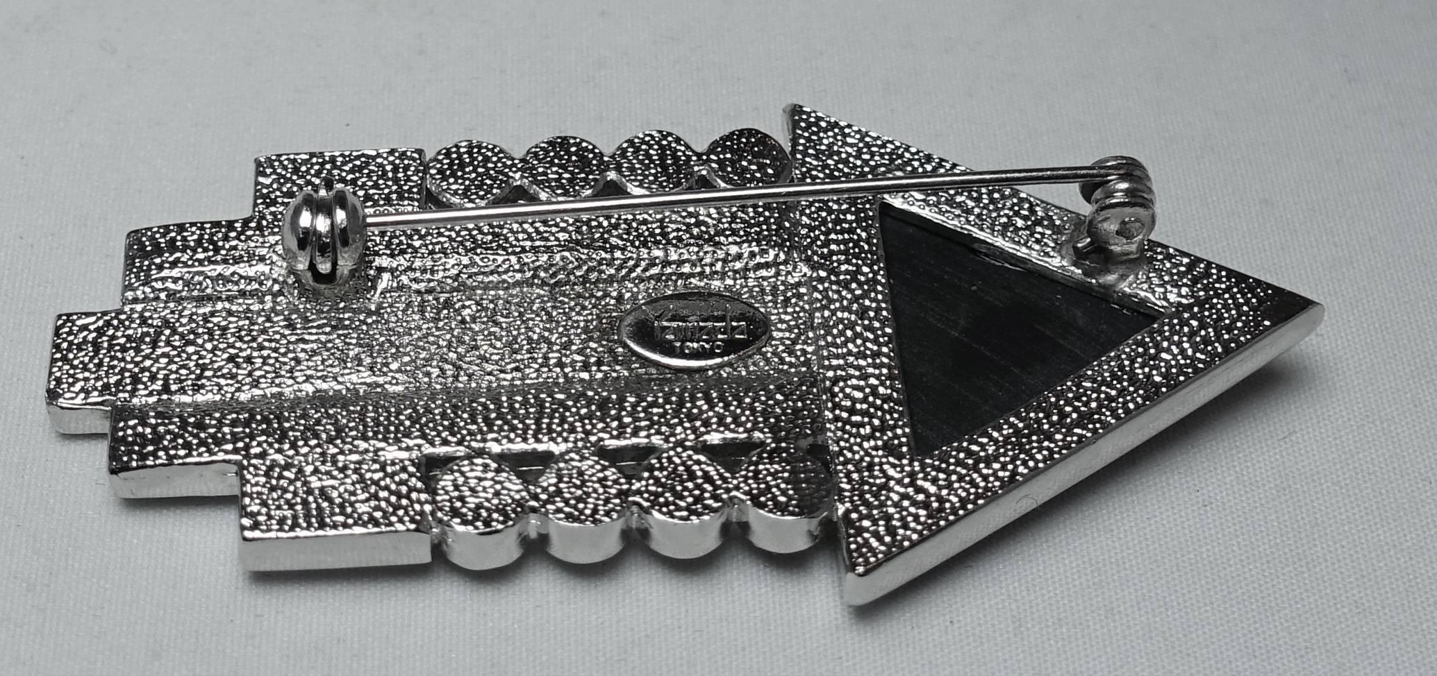 This is wonderful signed Yamada Tokyo arrow brooch has a Deco design. It has clear baguettes and round rhinestones. The front and center of the arrow has black enameling. This pin measures 2-1/2” x 1” and is signed “Yamada Tokyo”.  It is in