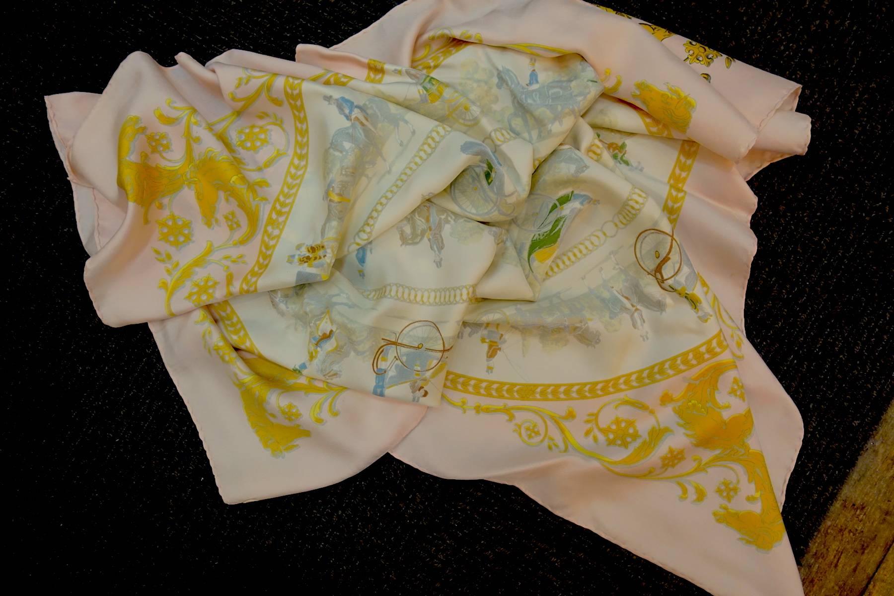 This vintage Hermès Paris silk scarf features the “La Promenade De Longchamps” design by Philippe Ledoux in shades of soft peach, yellow, green and beige. In excellent condition, this Hermes scarf measures approx. 34” x 35” with hand-rolled/stitched