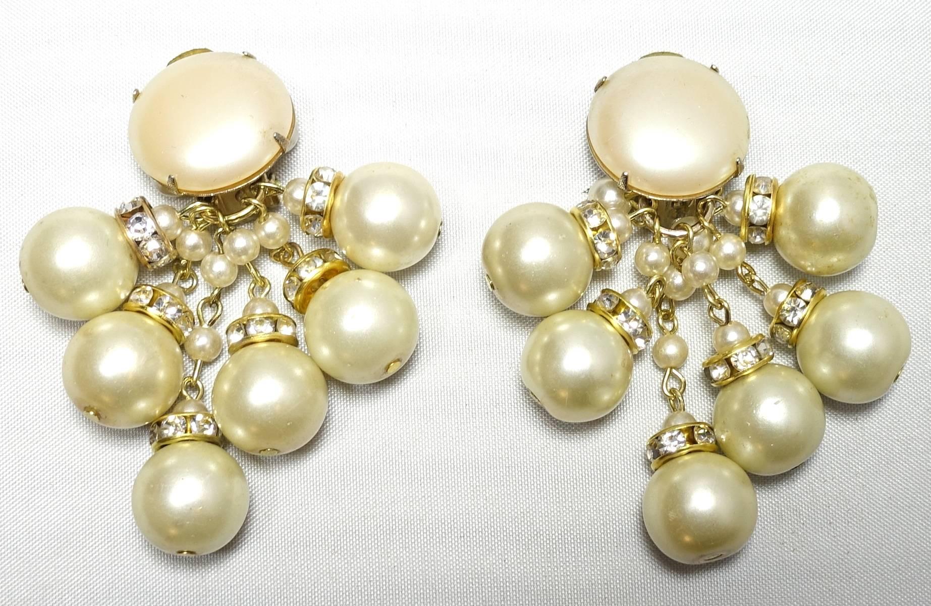 These vintage signed DeMario earrings feature faux pearls with crystal rhondells in a gold tone setting.  these clip earrings measure 2” x 1” and are signed “DeMario”. They are in excellent condition.