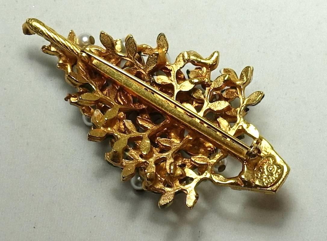 This signed Christmas tree brooch has green enameled leaves with faux pearls dangling from the leaves. This beautiful holiday brooch has a gold tone setting and measures 1-1/2” x 2-1/2” and is signed “Originals By Robert”.  It is in excellent